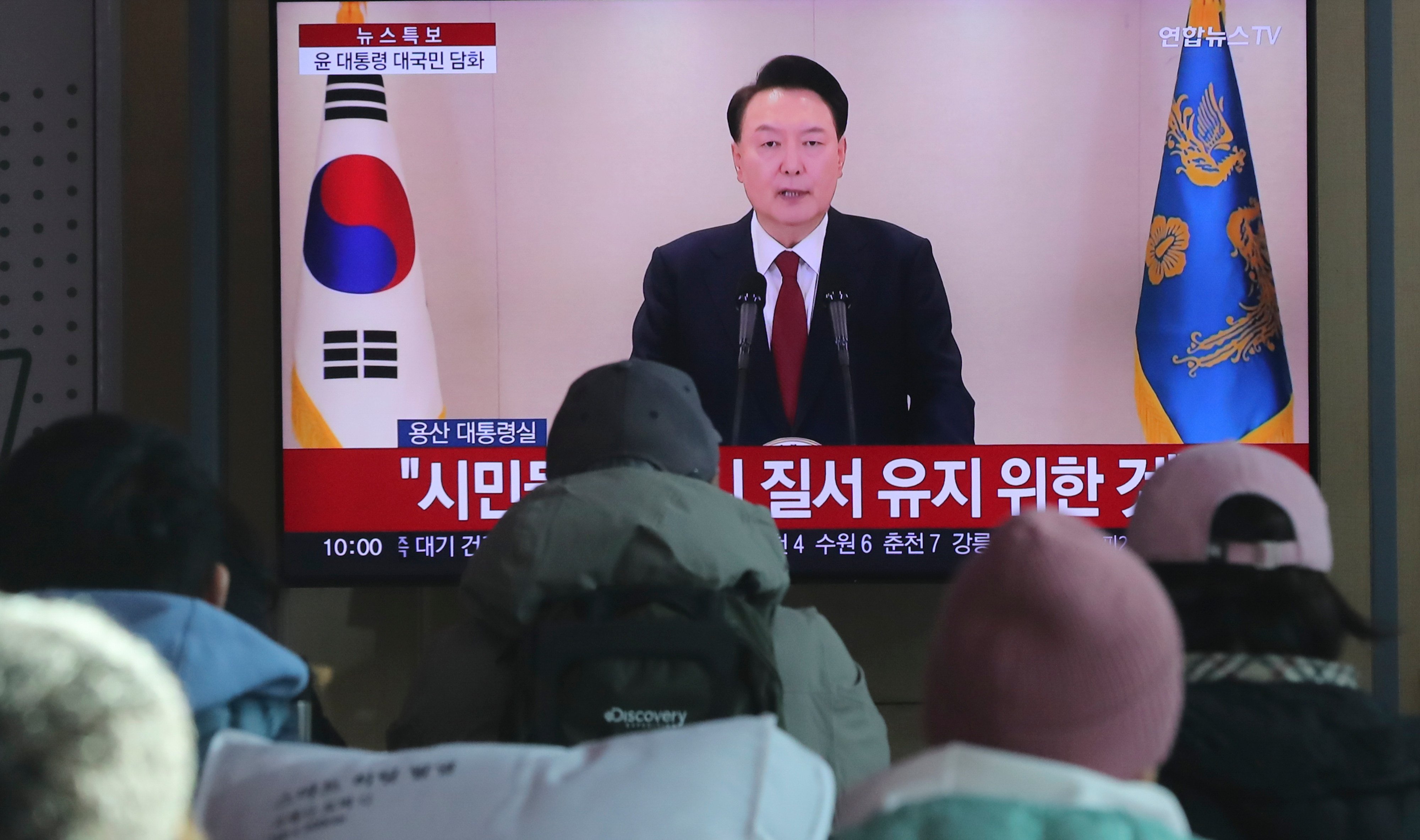 People watch a televised address by South Korean President Yoon Suk-yeol at Seoul Railway Station in Seoul on December 12. Photo: Xinhua