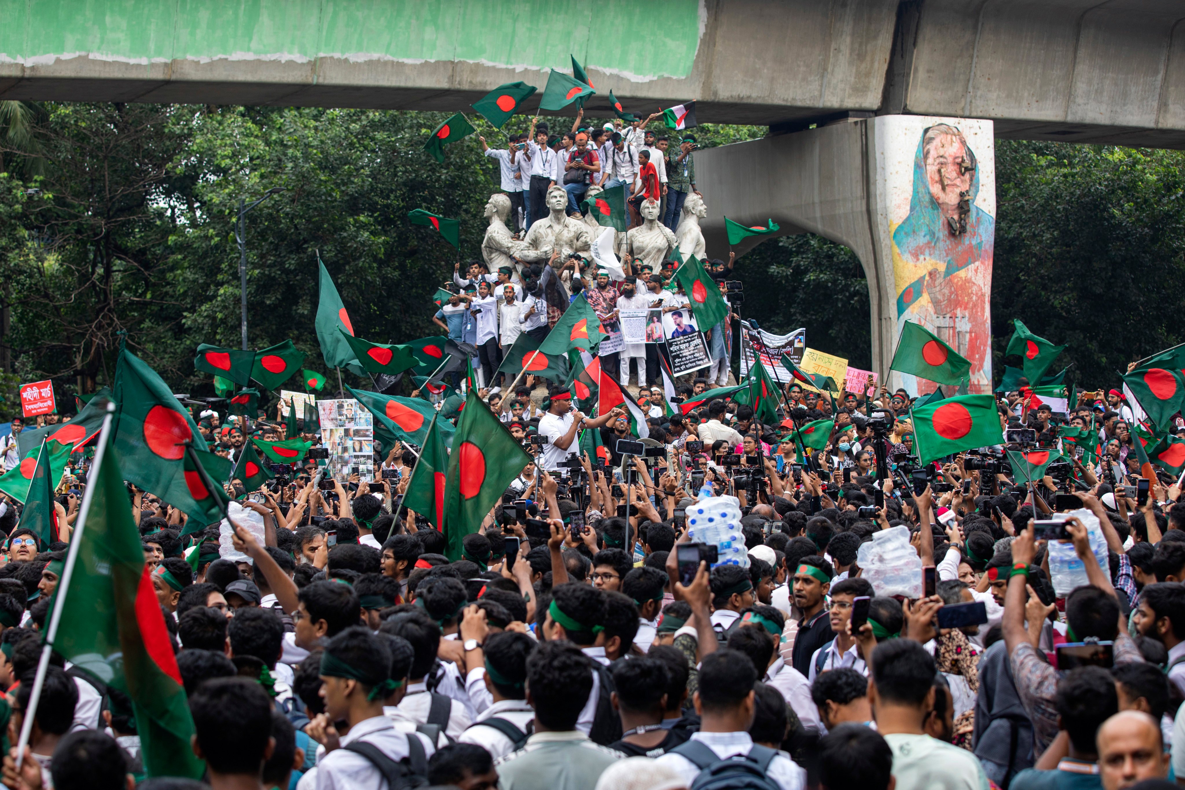 Students and other activists carry Bangladesh’s national flag during a protest march to mark one month since former Prime Minister Sheikh Hasina stepped down after a mass uprising, in Dhaka, Bangladesh, on September 5. Photo: AP