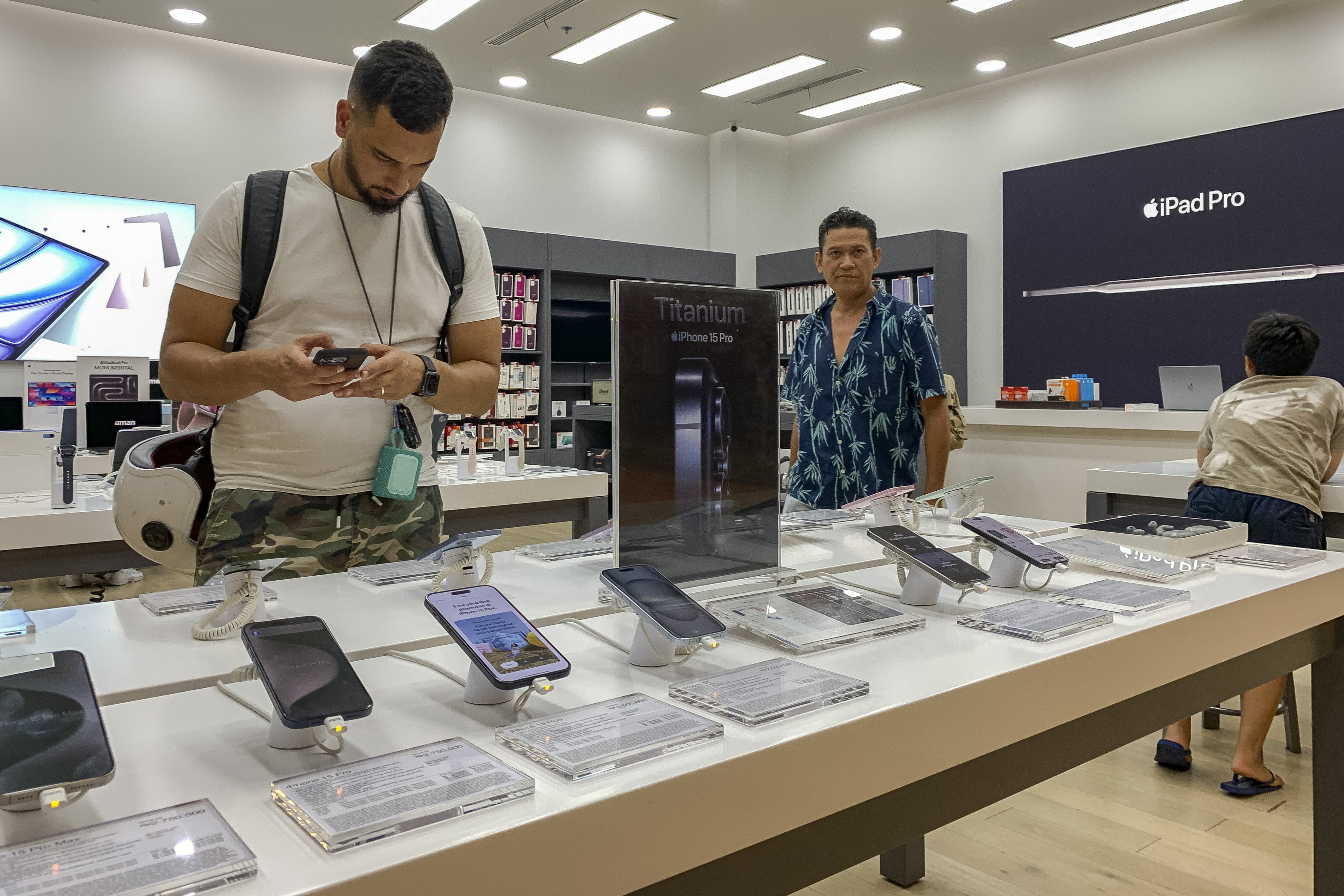 A customer inspects an Apple iPhone 15 at a mall in Denpasar, Indonesia’s Bali. Photo: EPA-EFE