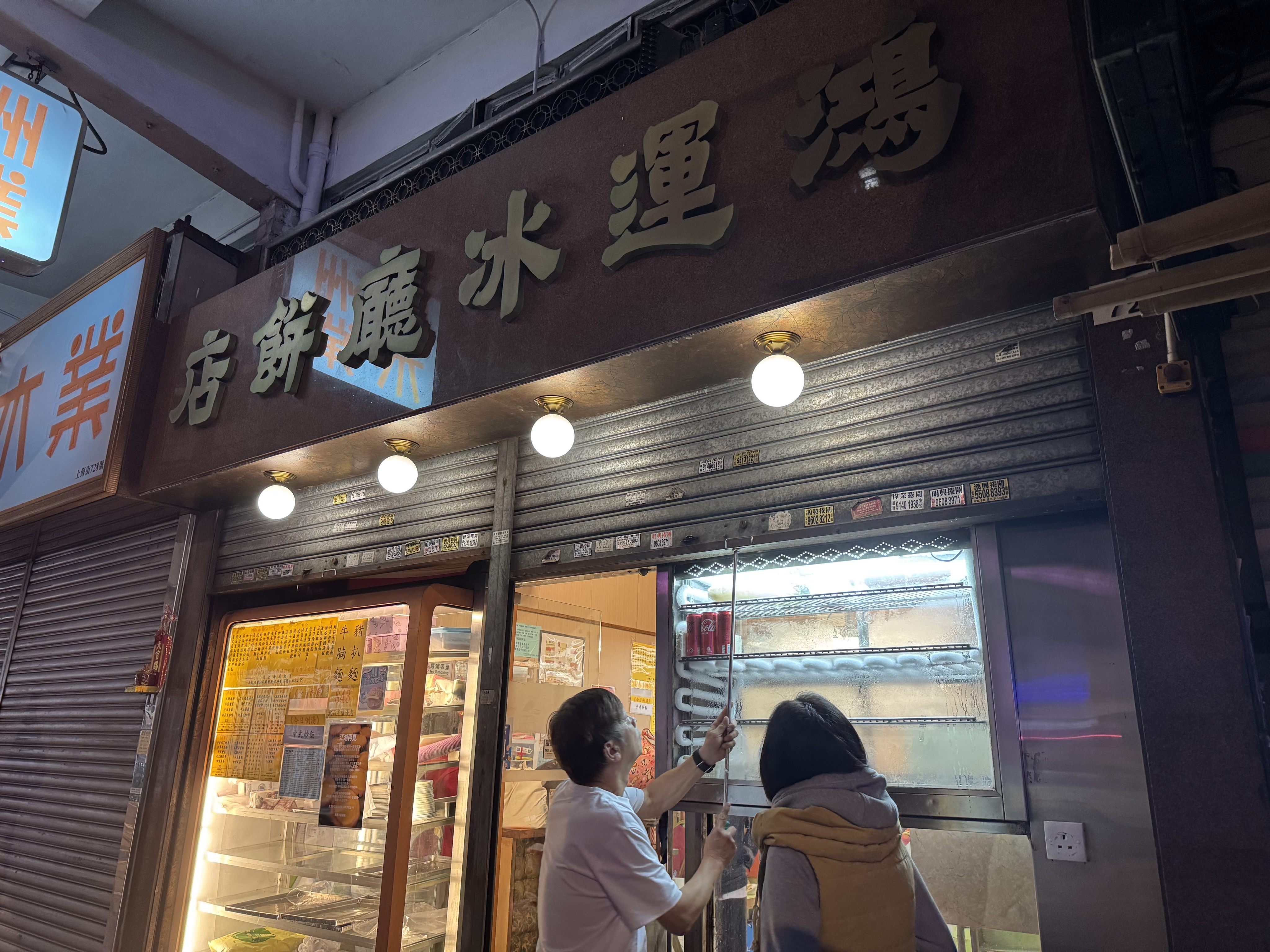 The owner of Hung Wan Cafe pulls down its metal shutters for the last time on Christmas Day. Photo: Jiang Chuqin