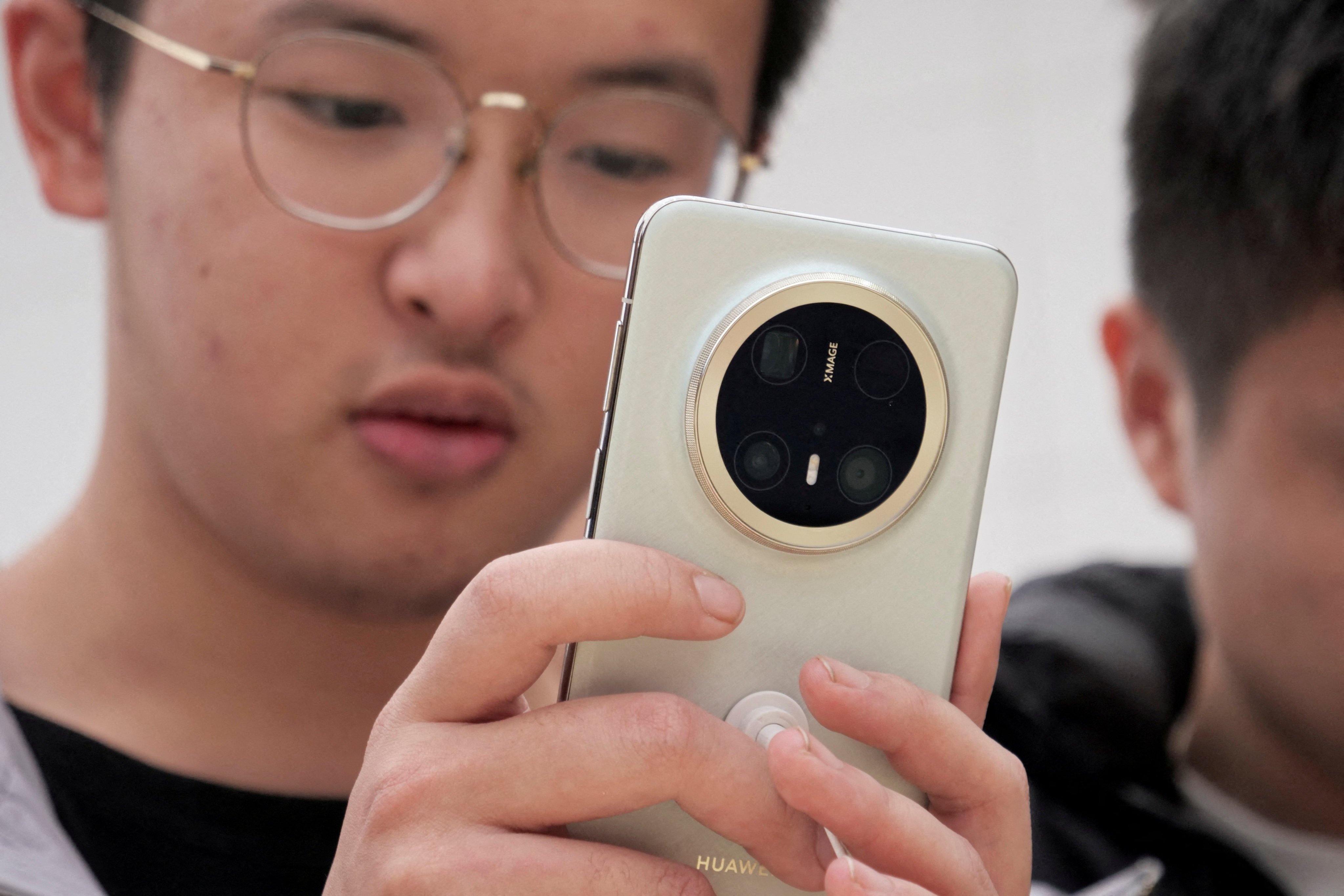 A visitor looks at Huawei’s latest Mate 70 smartphone series at a flagship store in Beijing. Photo: Reuters