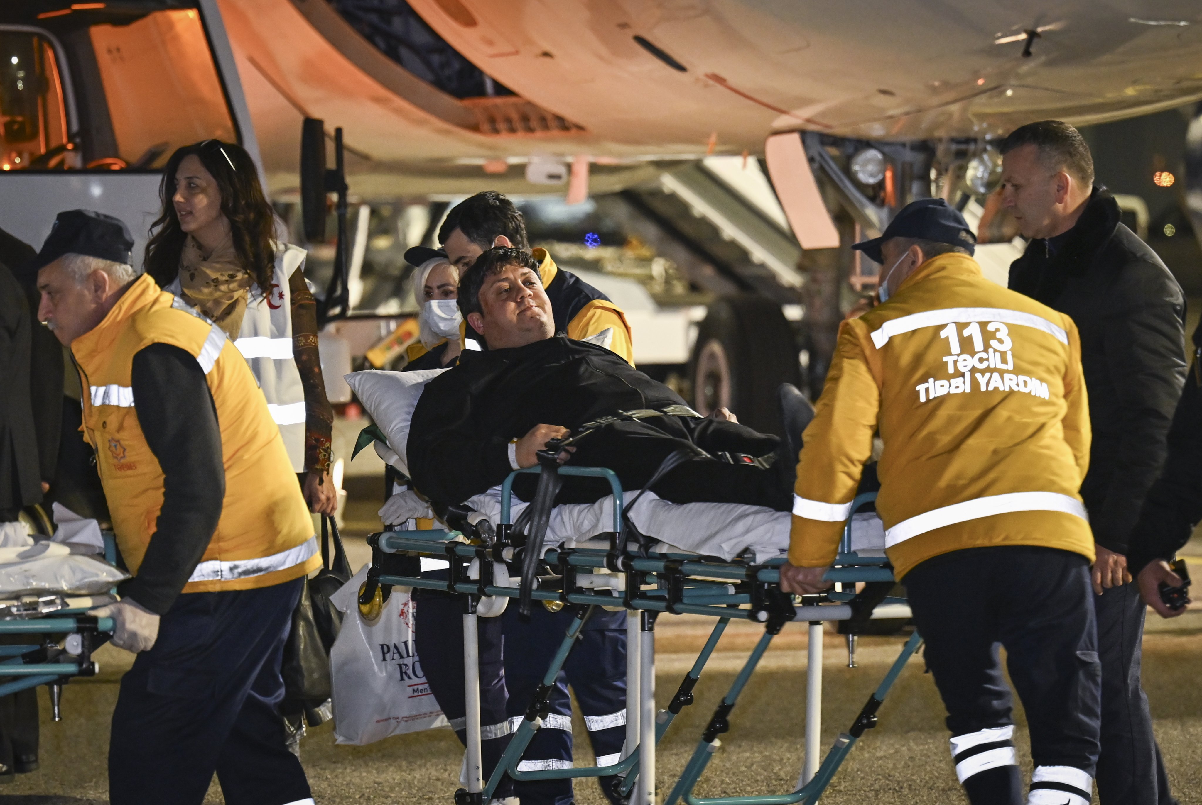 Rescuers carrying a passenger wounded in a Azerbaijan Airline plane crash in Kazakhstan, arrive with a medical plane at an airport outside Baku. Photo: EPA-EFE