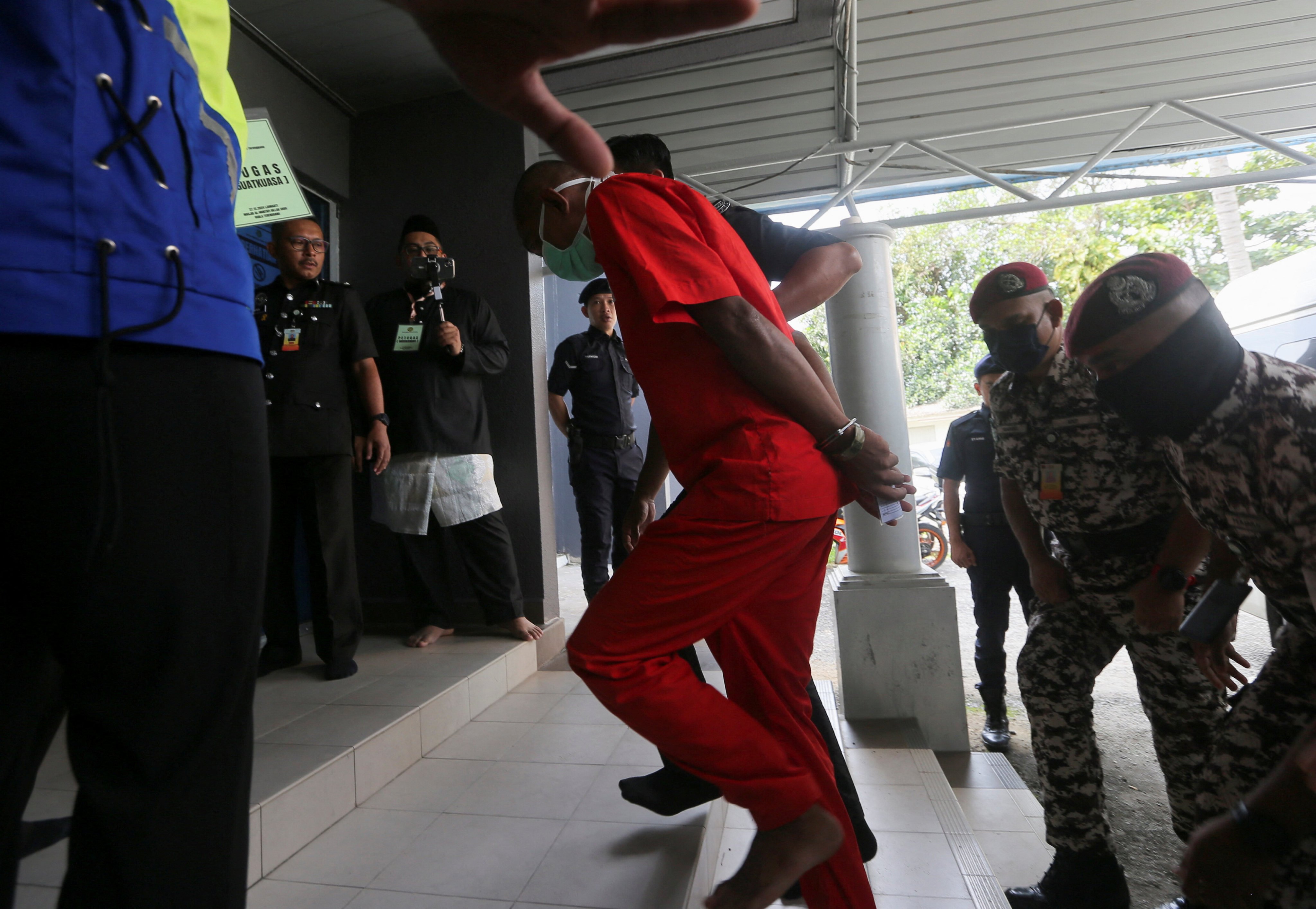 Mohd Affendi Awang, a 42-year-old father of five is escorted by a prison guard to face a public caning at a mosque, after being repeatedly convicted of the Islamic crime of ‘khalwat’, or close proximity between unmarried couples, at Kuala Terengganu, Malaysia on December 27. Photo: Reuters