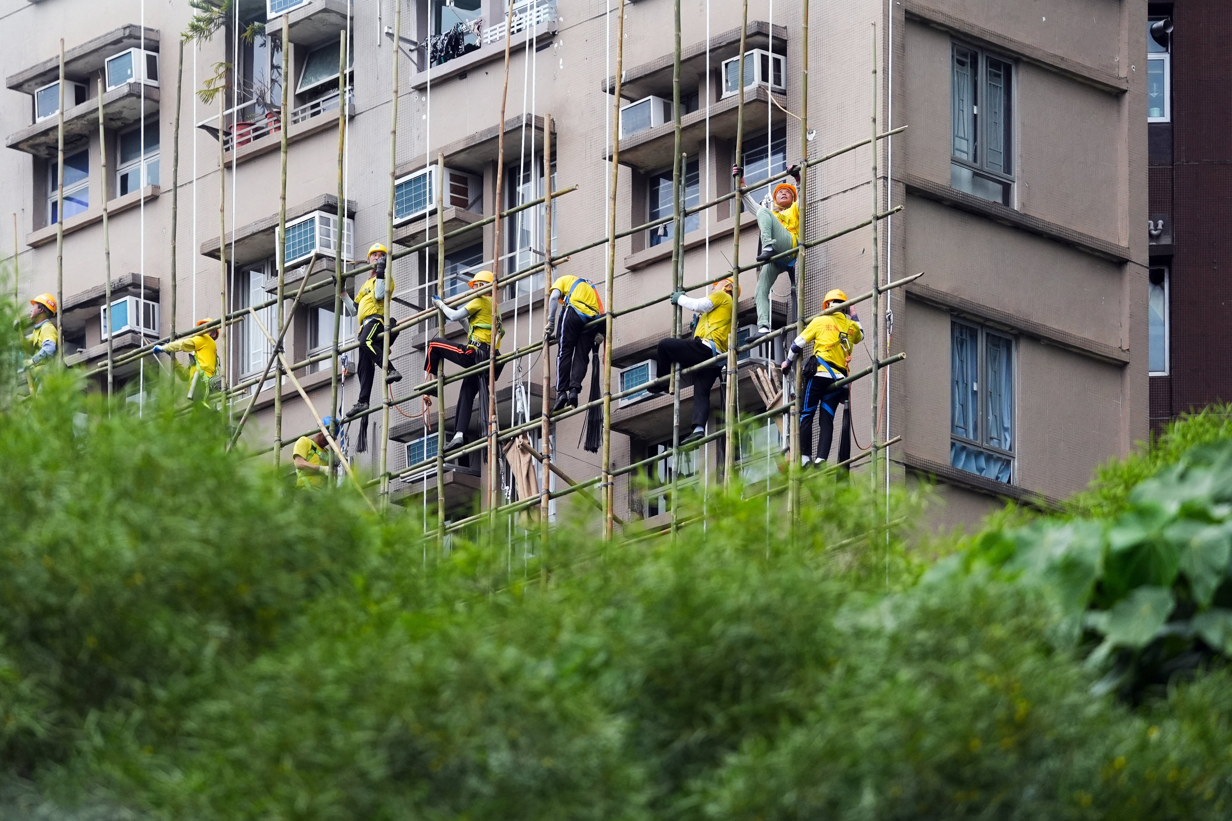 Workers climb scaffolding in Tai Po on December 9. Photo: Eugene Lee