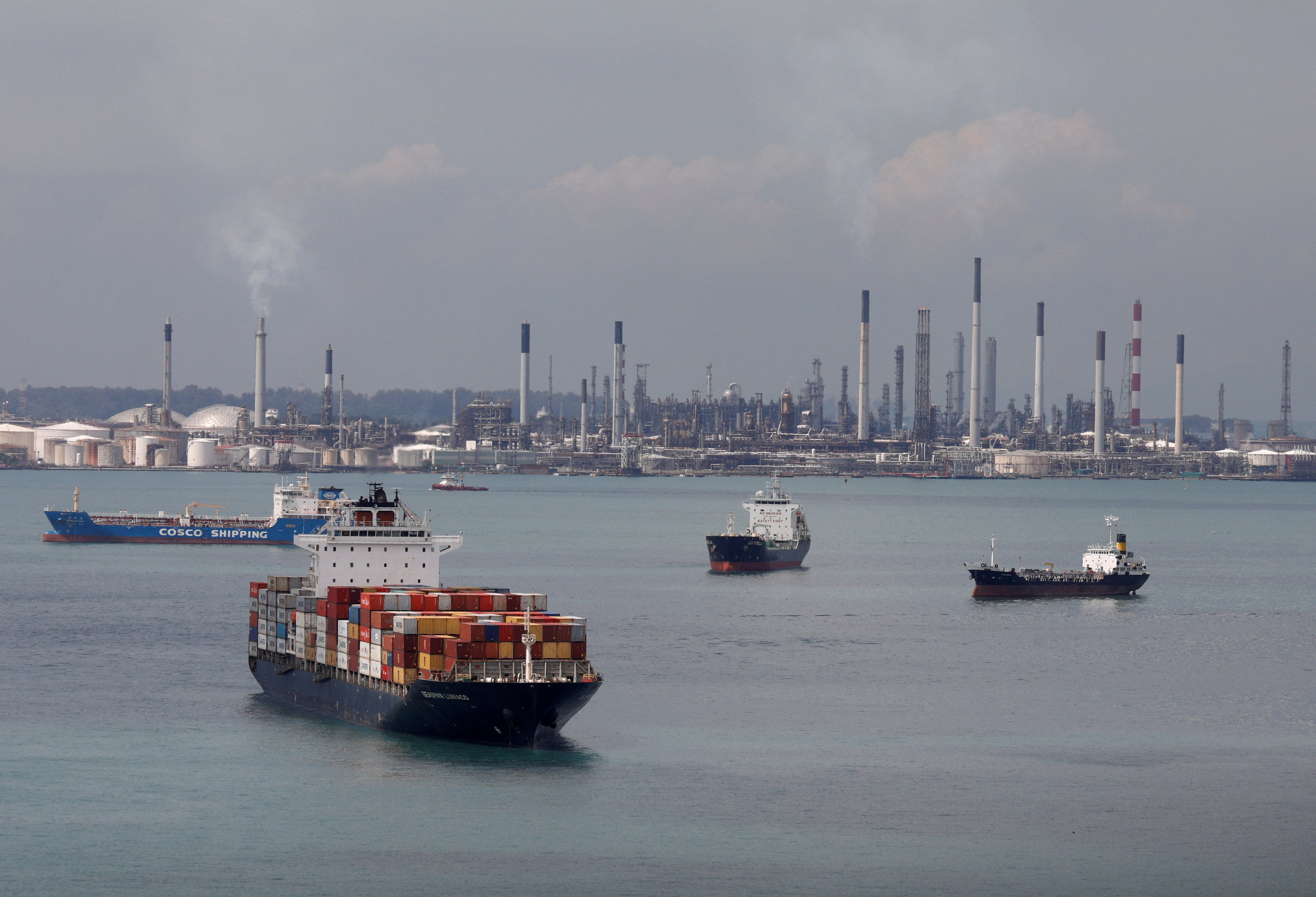 A container ship passes Shell’s Pulau Bukom refinery in Singapore. Photo: Reuters