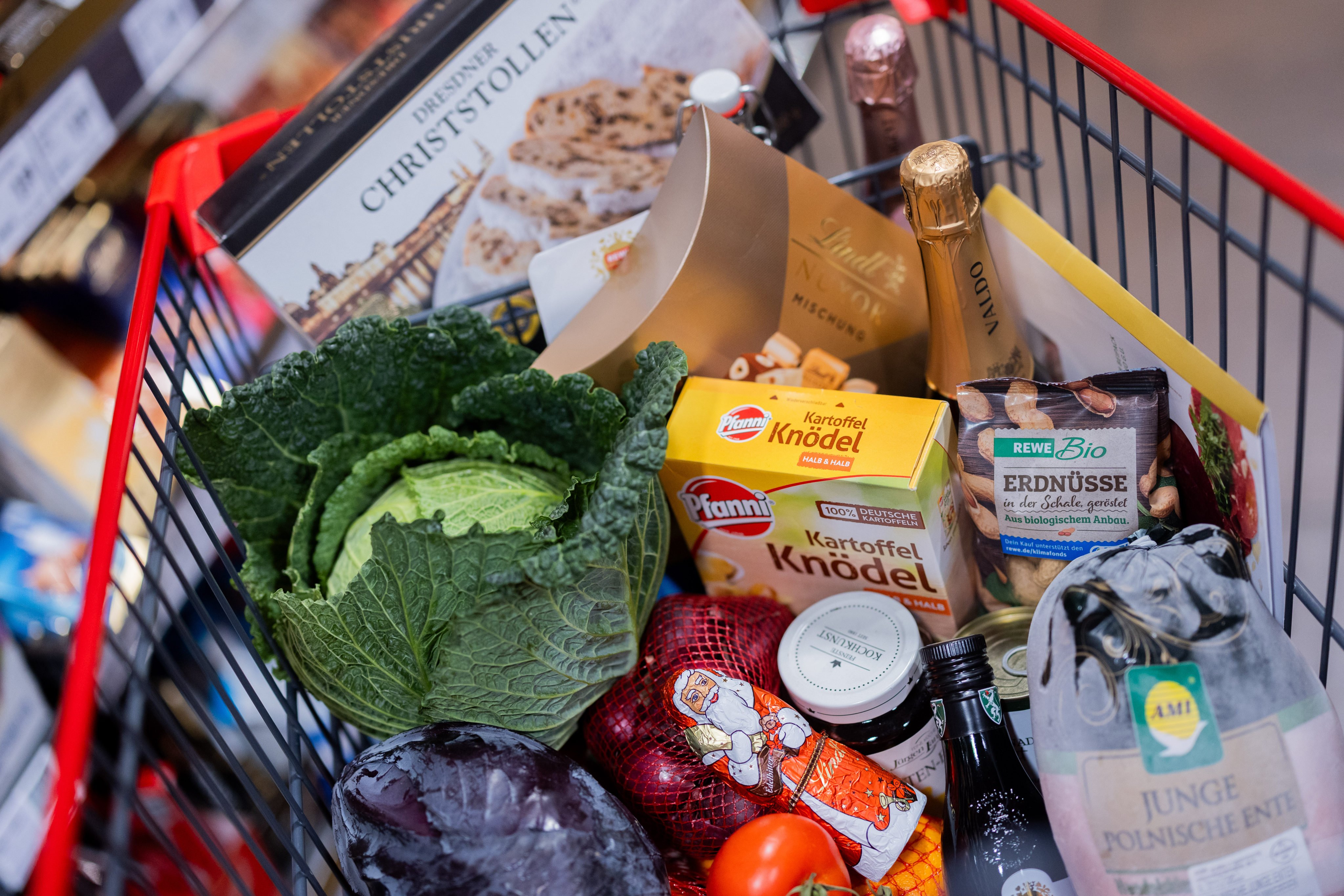 A shopping cart filled with goods is pushed past shelves in a supermarket in Cologne, Germany on December 4. Photo: dpa