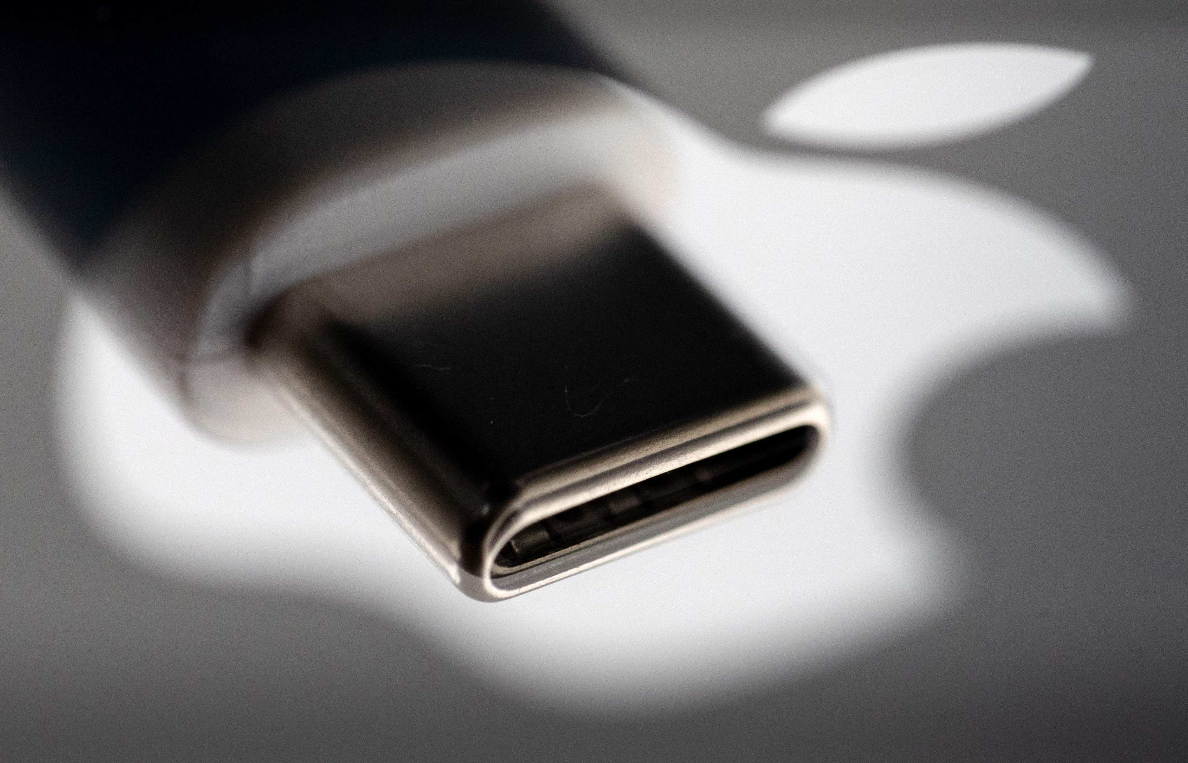 A USB-C plug reflected on the Apple logo. Photo: AFP