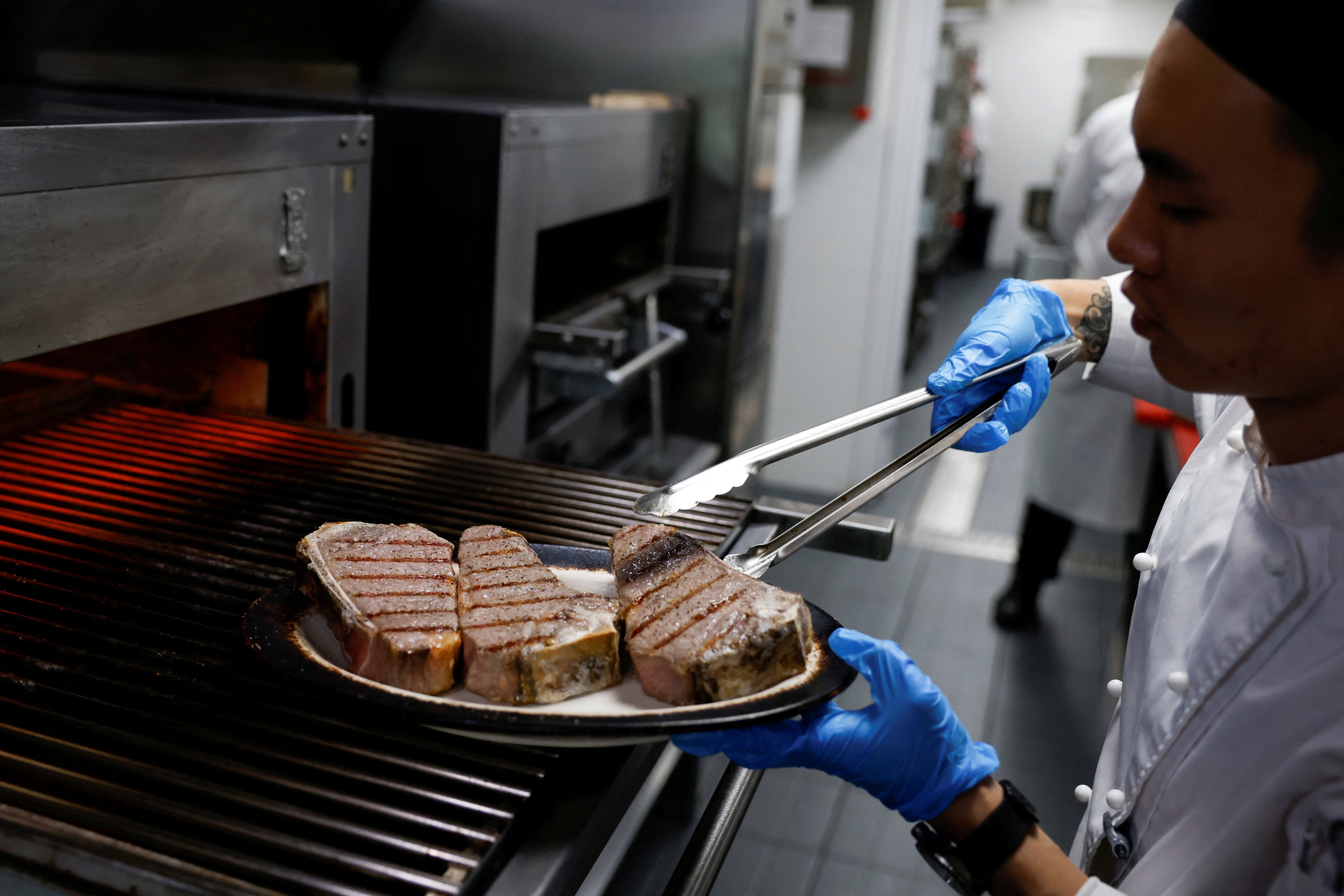 A chef cooks beef steaks at Wolfgang’s Steakhouse in Beijing. Photo: Reuters