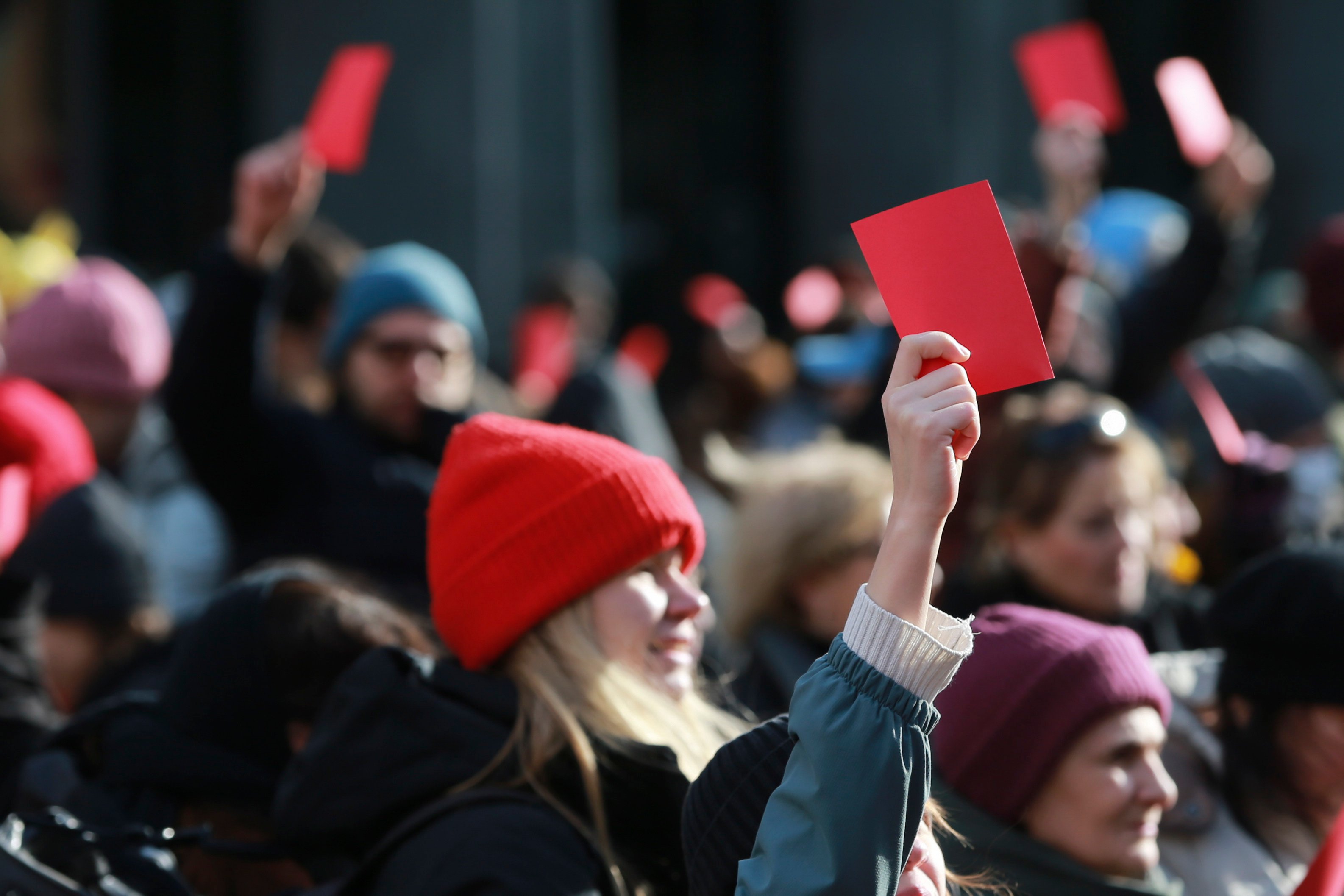 Demonstrators hold red cards outside of the Georgian parliament. Photo: AP