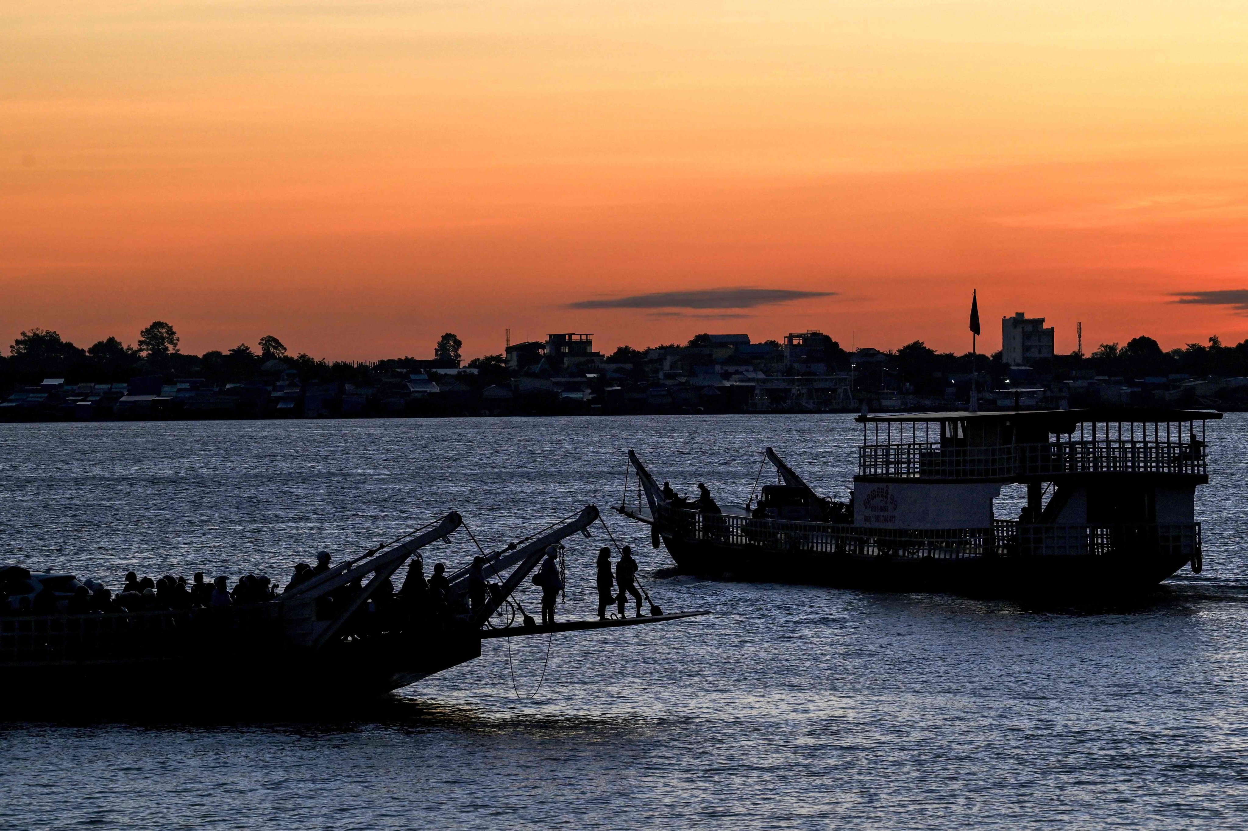 Ferries sail along the Mekong River at dawn in Phnom Penh on August 13. The river has become a hotspot for sand mining. Photo: AFP