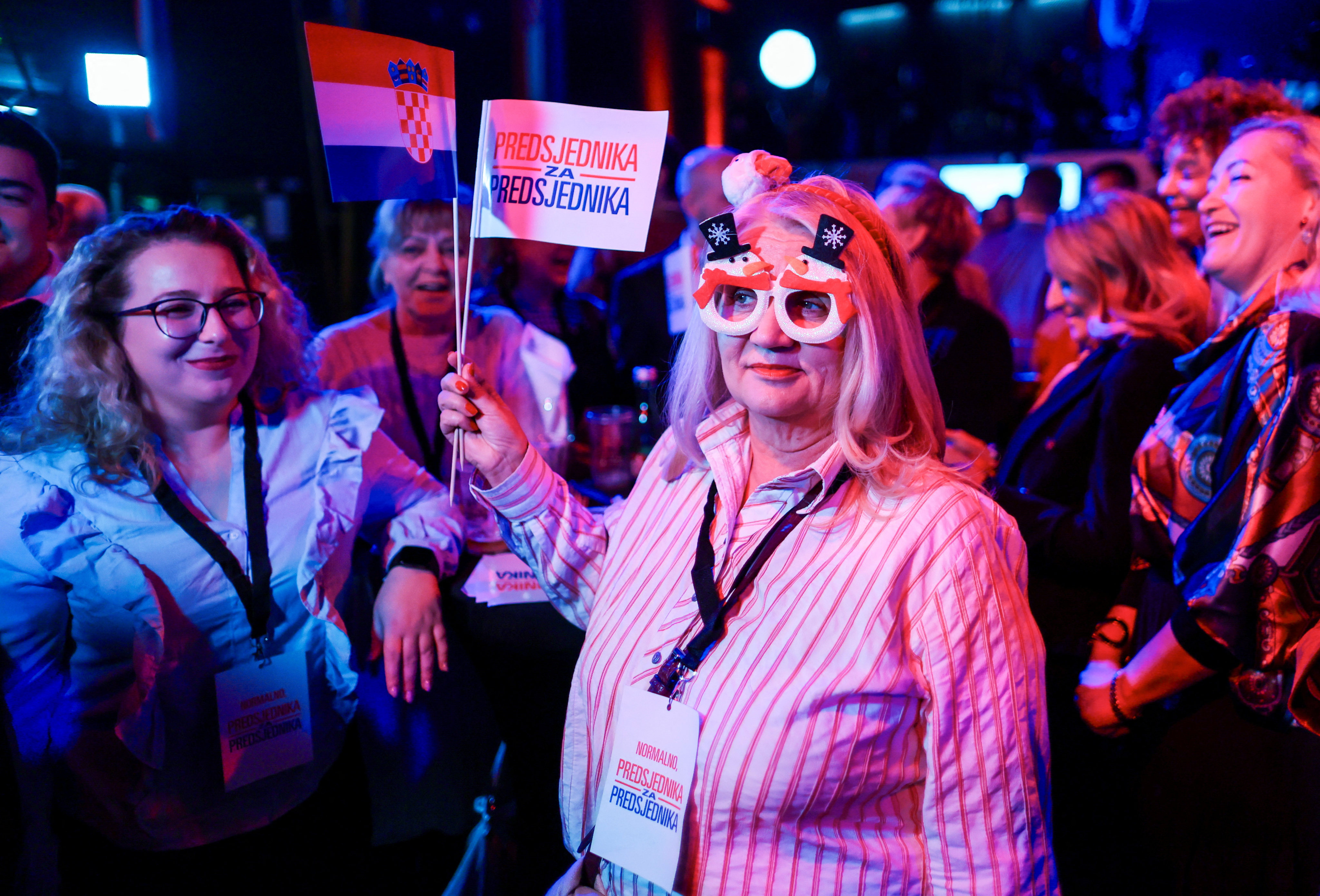 Supporter of Croatian President and presidential candidate Zoran Milanovic hold flags after the first unofficial results of Croatia’s presidential election were announced in Zagreb, Croatia on Sunday. Photo: Reuters