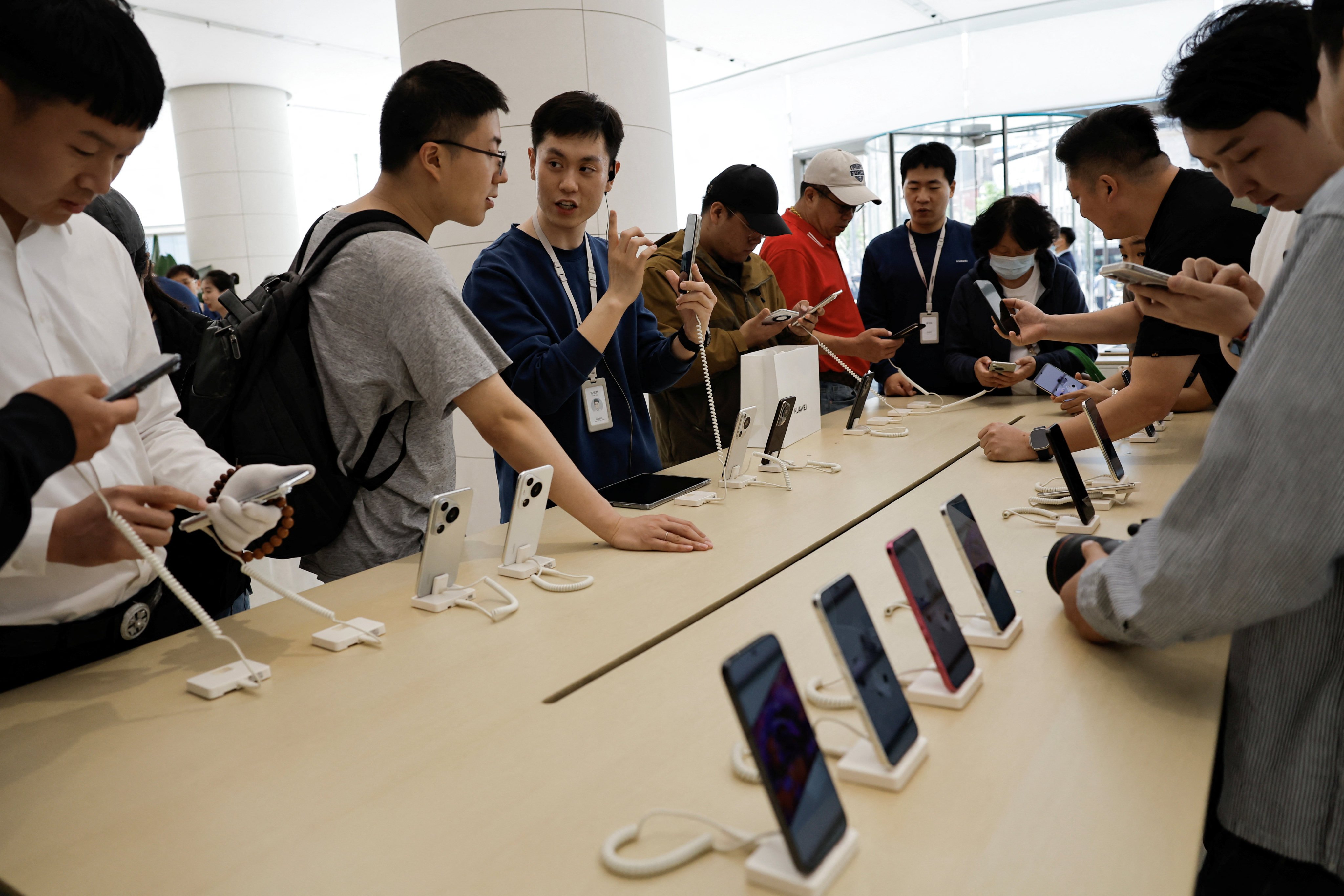 Customers look at Huawei’s Pura 70 series smartphones at a flagship store in Beijing. Photo: Reuters