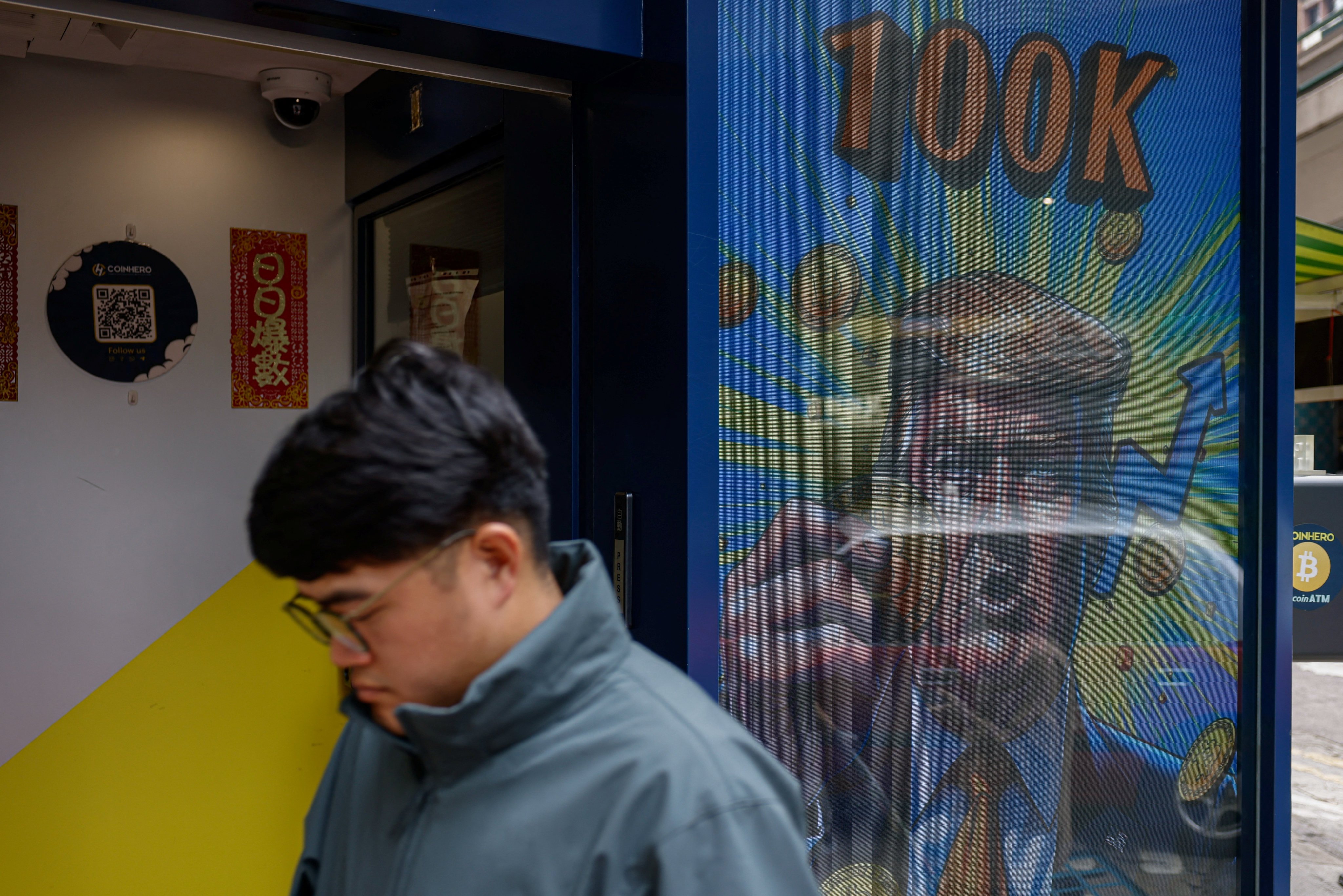 An illustration featuring Donald Trump holding a bitcoin is displayed outside a cryptocurrency exchange store in Hong Kong after the digital asset soared above US$100,000 on December 5, 2024. Photo: Reuters