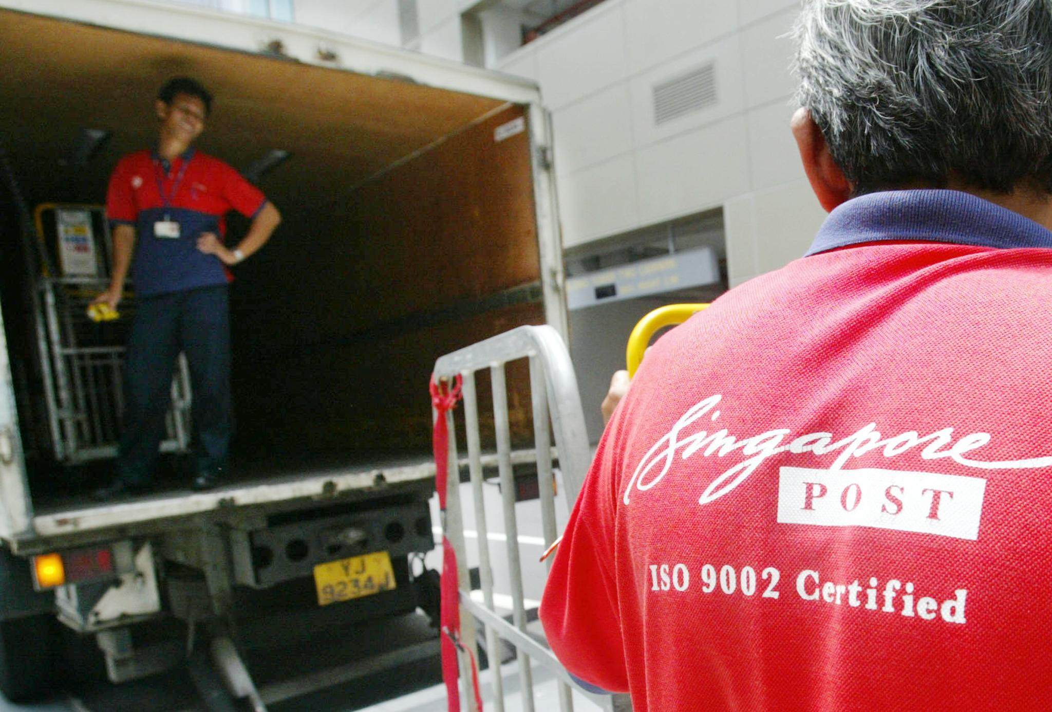 A SingPost worker prepares to load parcels and letters on a lorry in Singapore. Photo: AFP