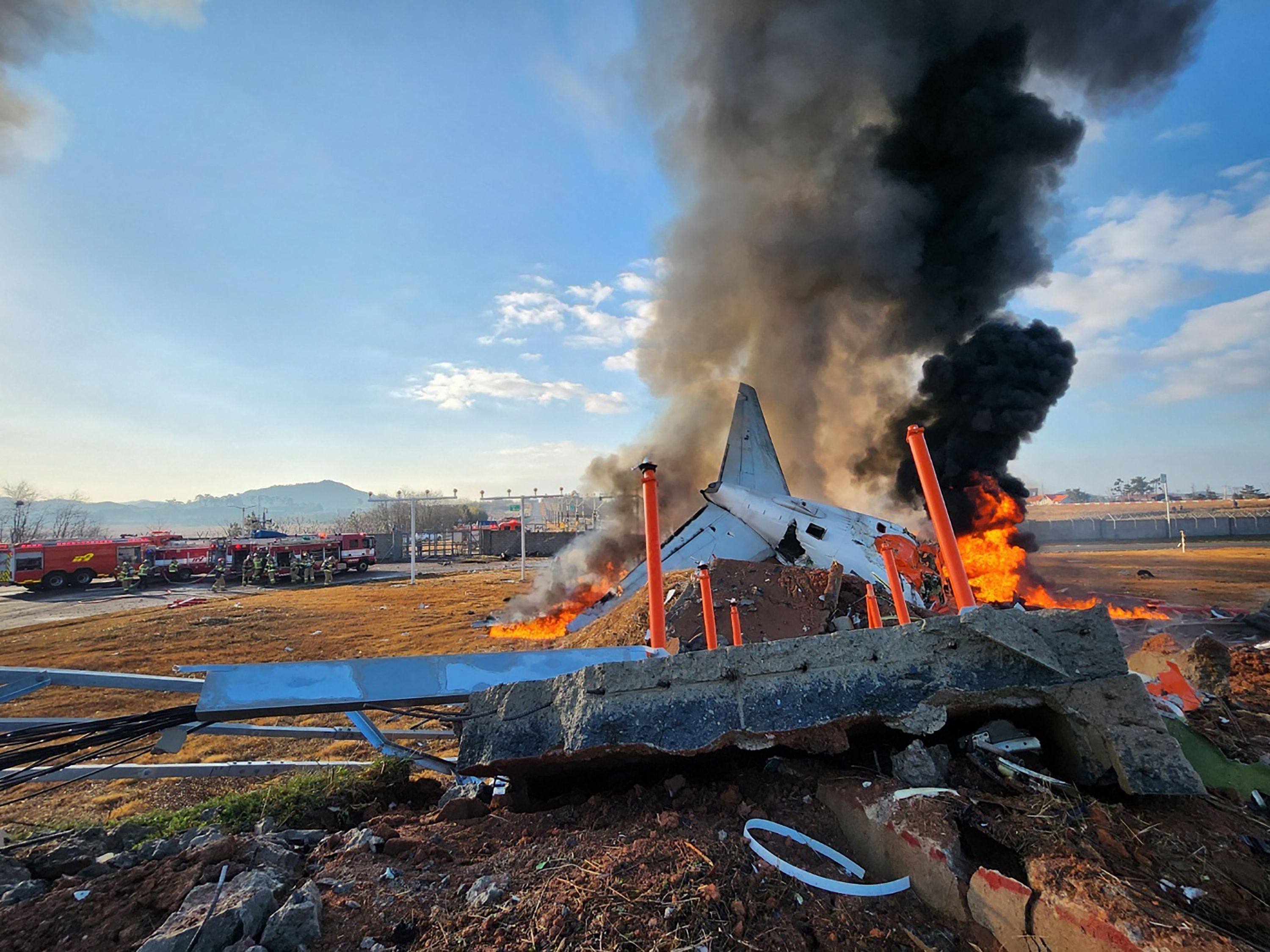 Fire and smoke rise from the tail section of a Jeju Air Boeing 737-800 series aircraft after the plane crashed and burst into flames at Muan International Airport. Photo: Yonhap/AFP