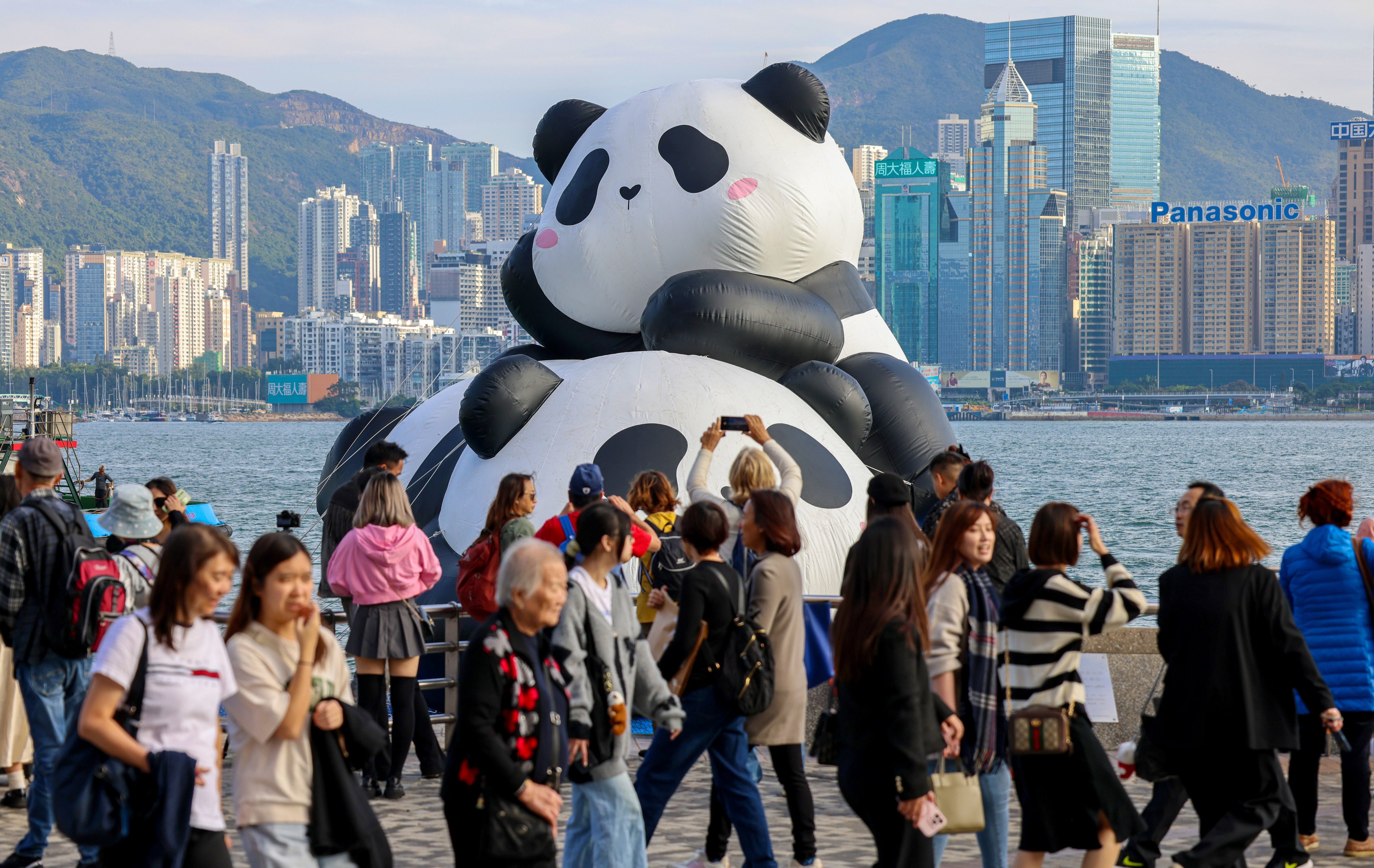 Tourists take photos with two giant inflatable giant pandas. Photo: Jelly Tse