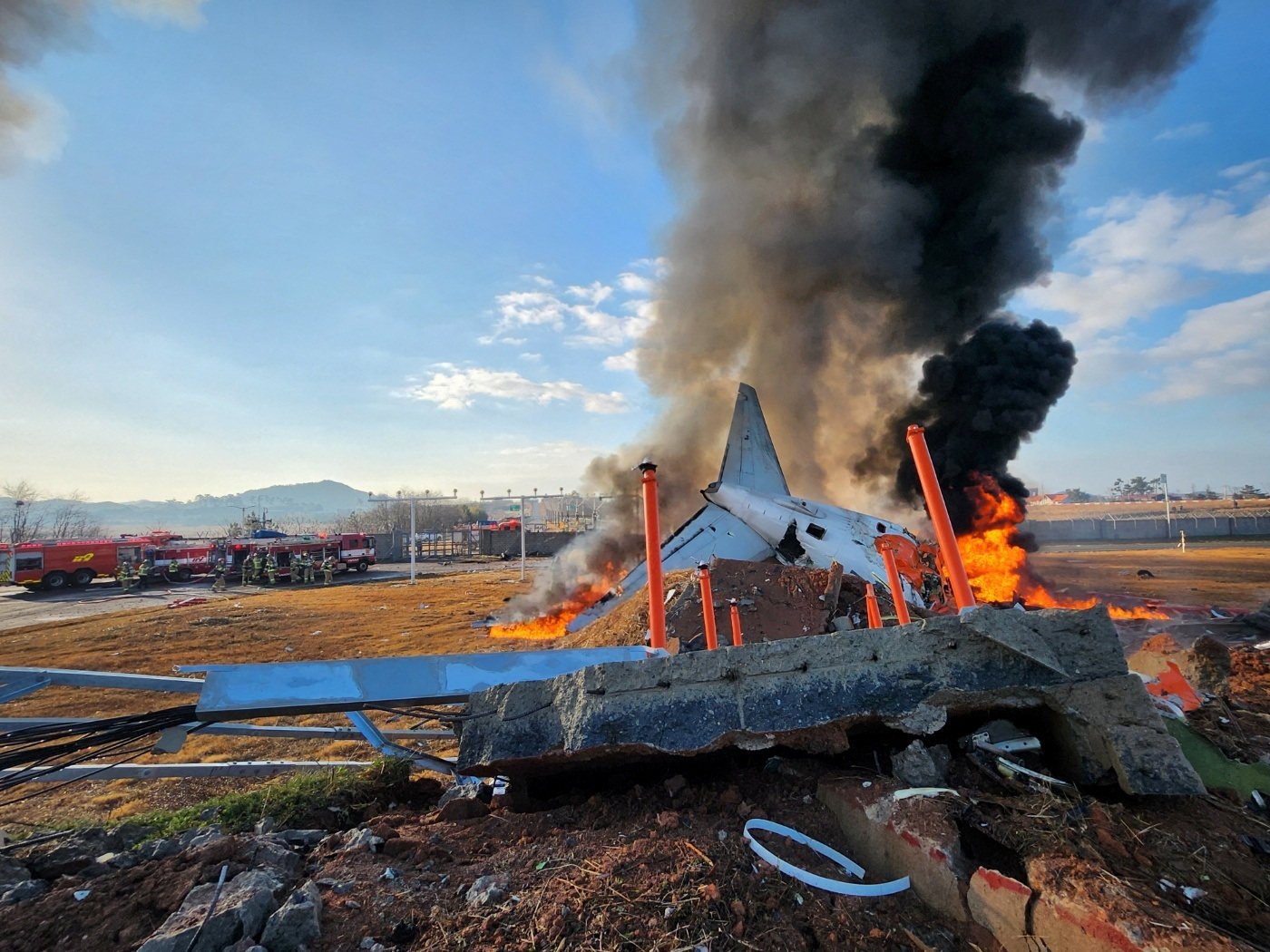 Firefighters carry out extinguishing operations on an aircraft which drove off runaway at Muan International Airport in Muan. Photo: Reuters