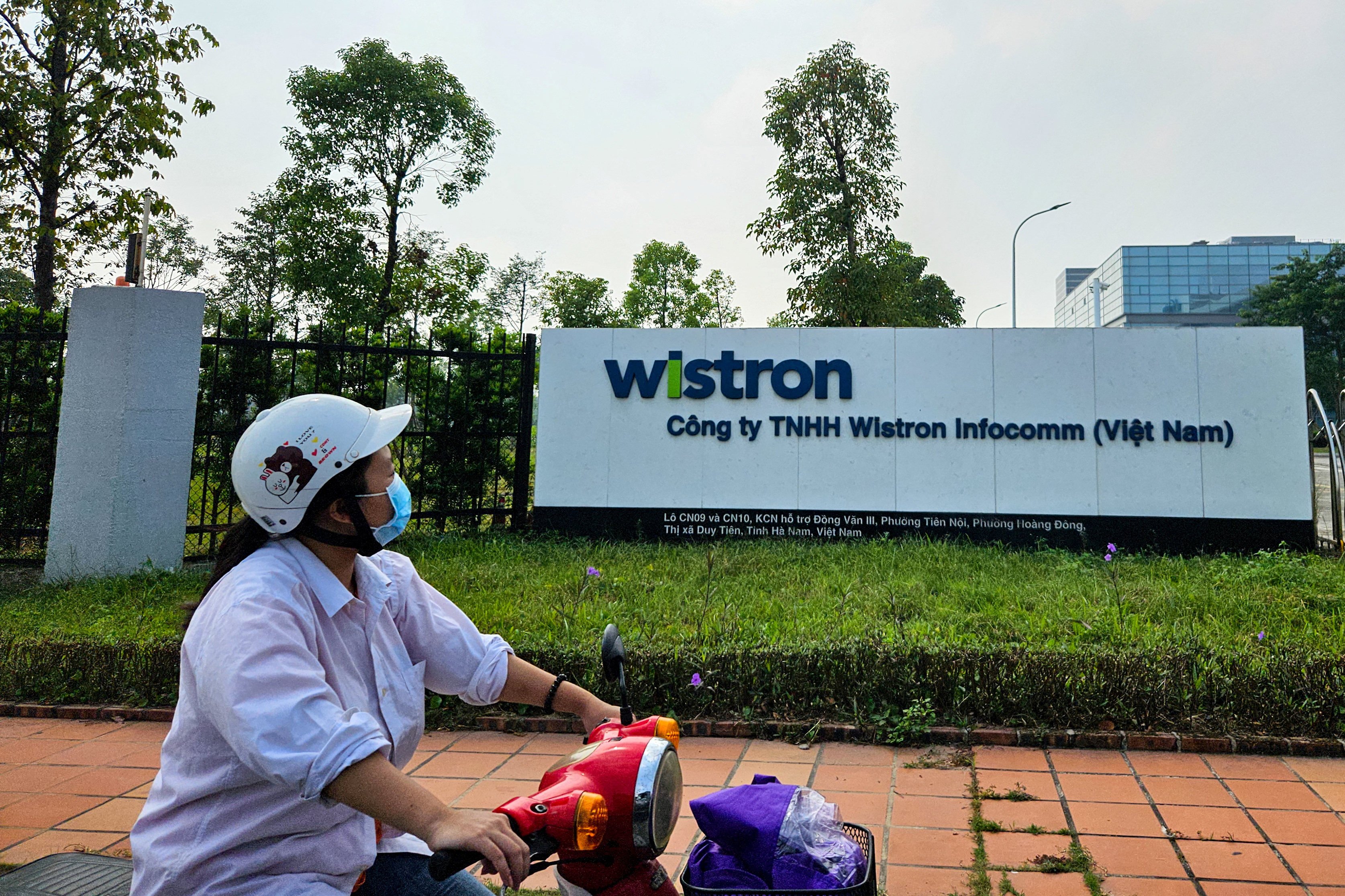 A woman rides past the Wistron NeWeb Corporation factory in Ha Nam, Vietnam, on October 11. The plant is expanding to produce satellite equipment for SpaceX. Photo: Reuters