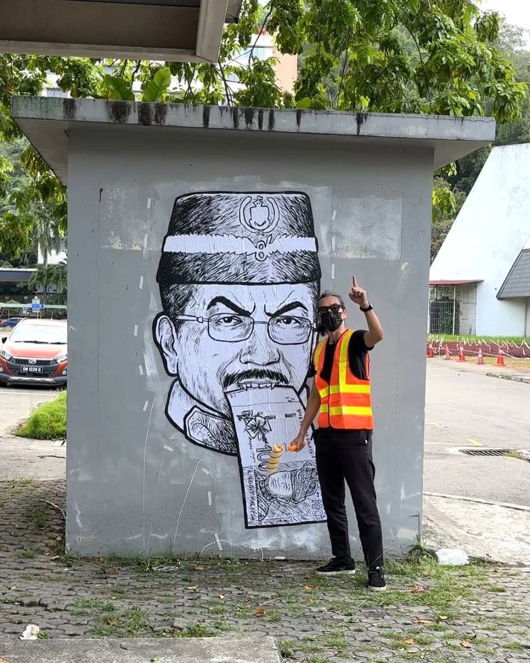 Malaysian satirist Fahmi Reza poses with a caricature on Musa Aman. Photo: Instagram/kuasasiswa