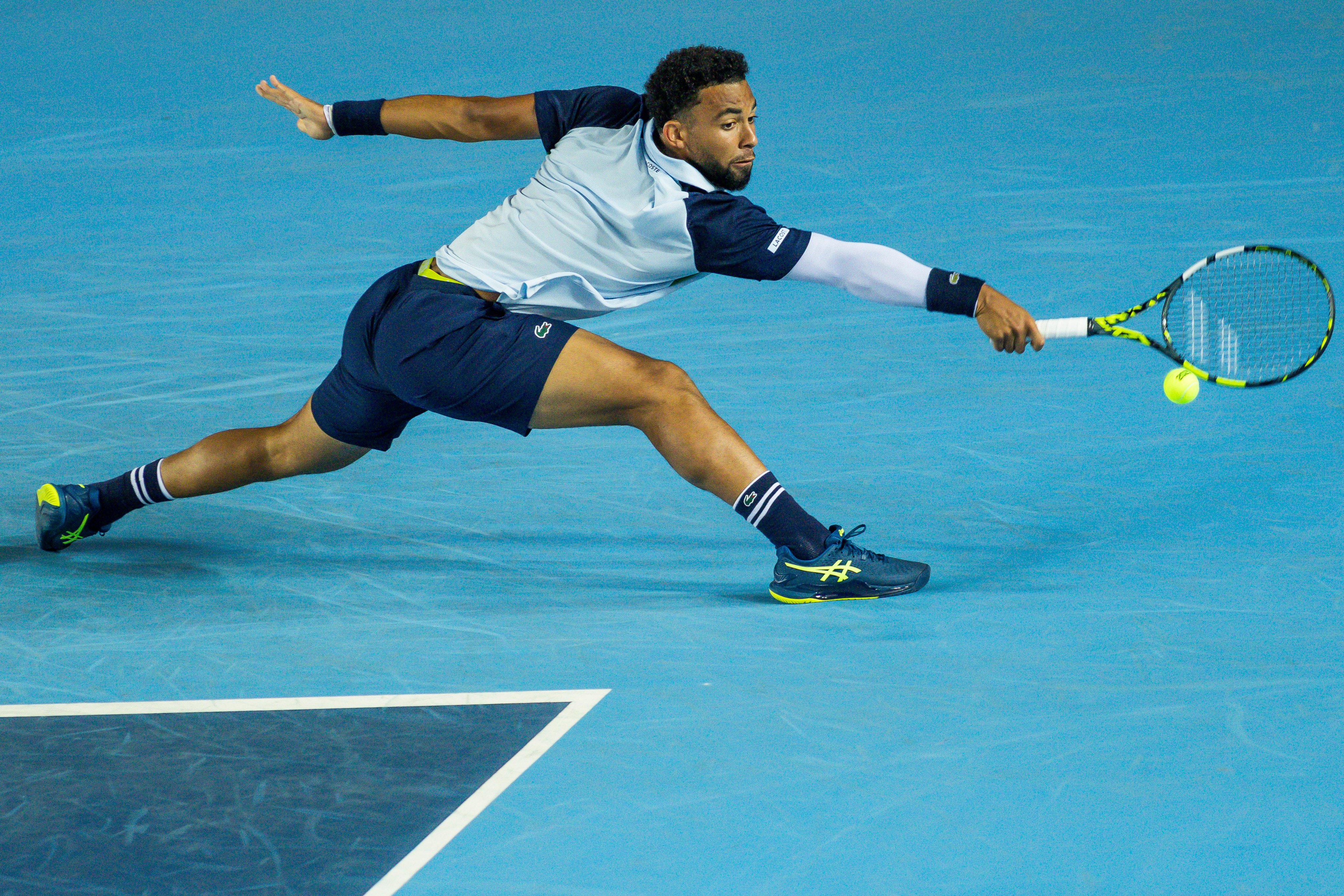 Arthur Fils slides to reach a backhand in his Bank of China Hong Kong Open victory over Zizou Bergs. Photo: Getty Images