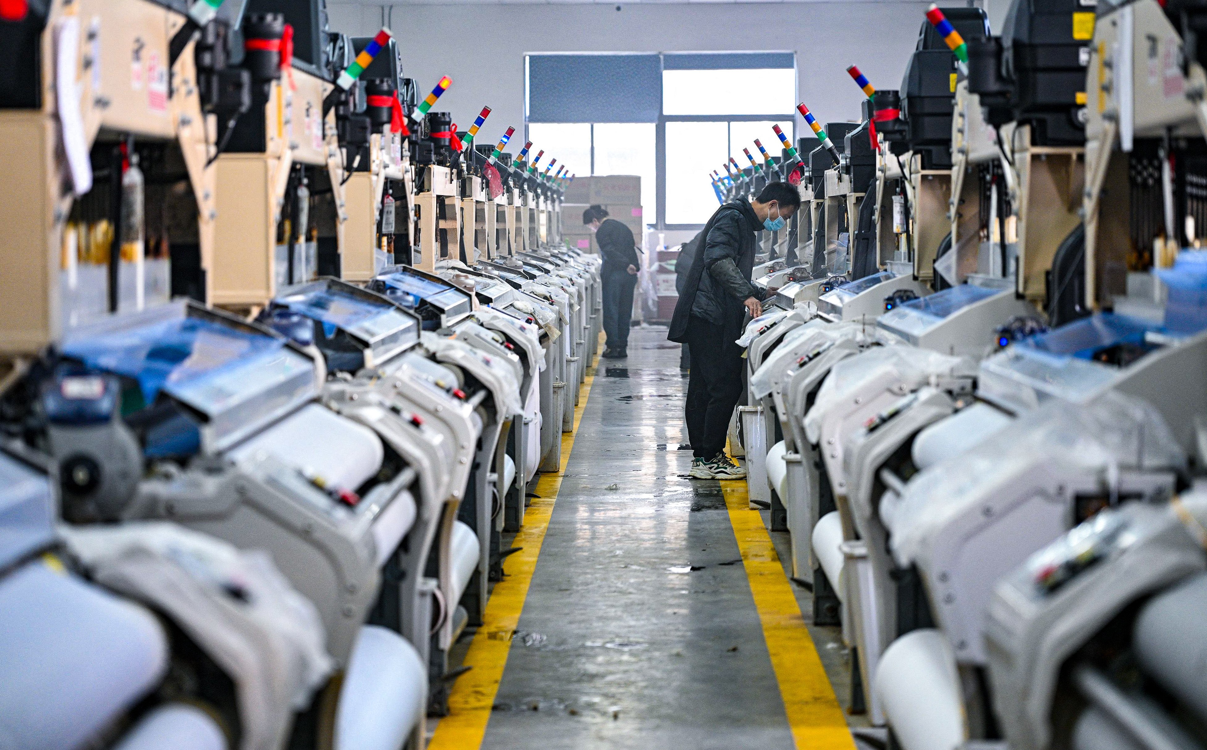 Staff work on a production line at a texile factory in China’s Jiangsu province. The nation’s factory activity grew in December, but at a slower-than-expected pace. Photo: AFP