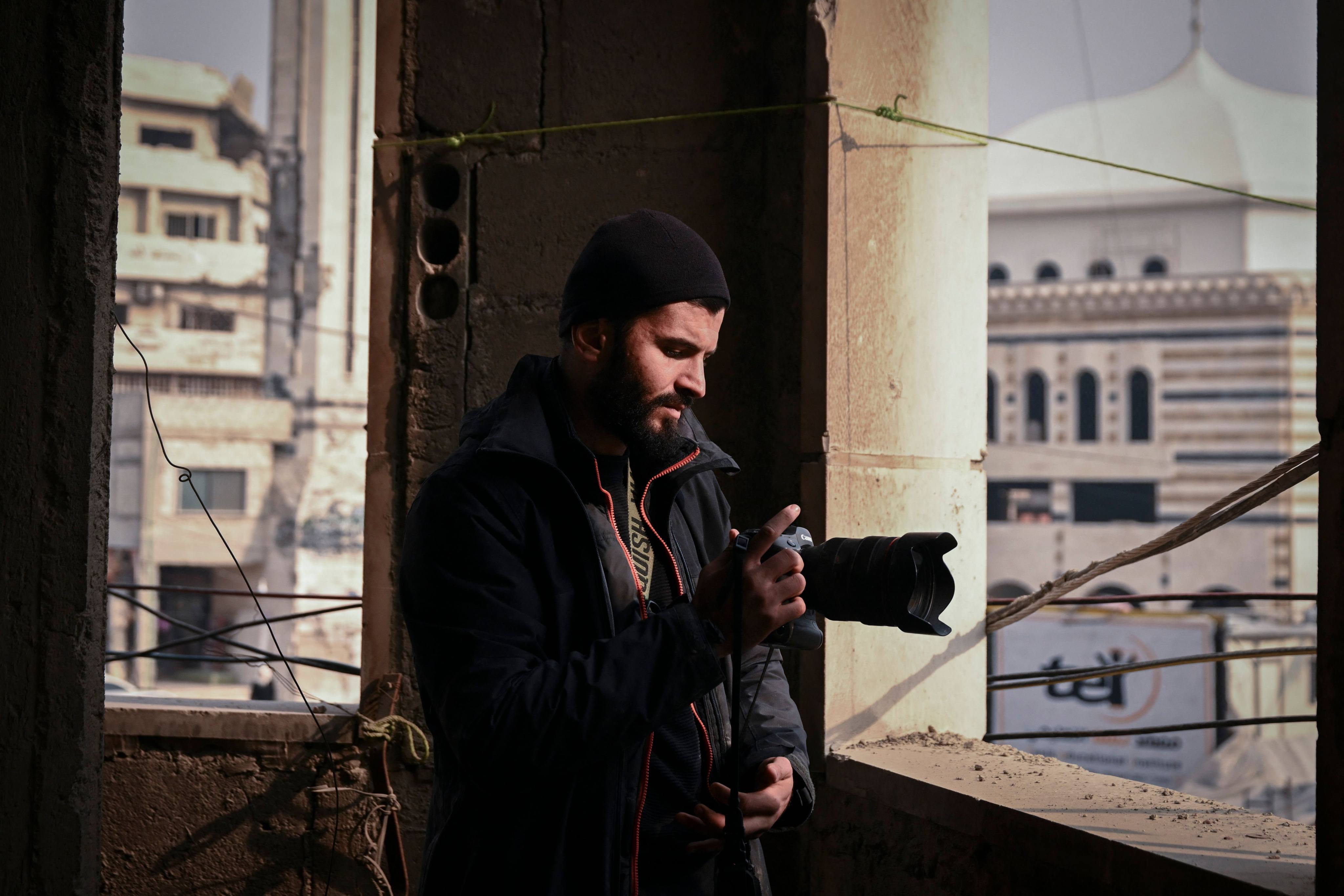 France-based photojournalist Sameer al-Doumy photographs Douma from a damaged building. He says returning to his Syrian hometown doesn’t offer comfort. Photo: AFP