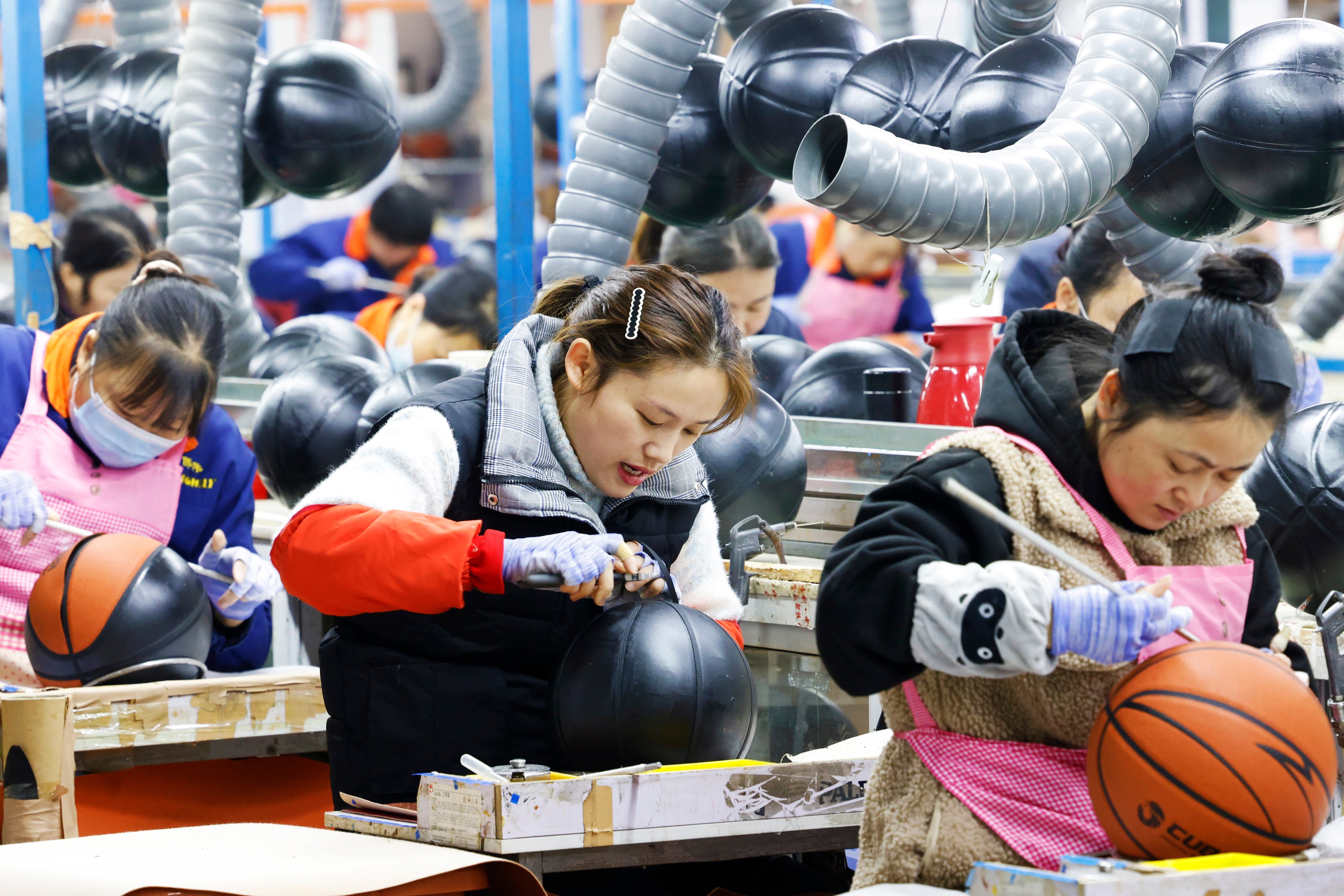 Employees work on basketballs for export at a company in Suqian in China’s Jiangsu province on December 27. Photo: VCG/ Getty Images