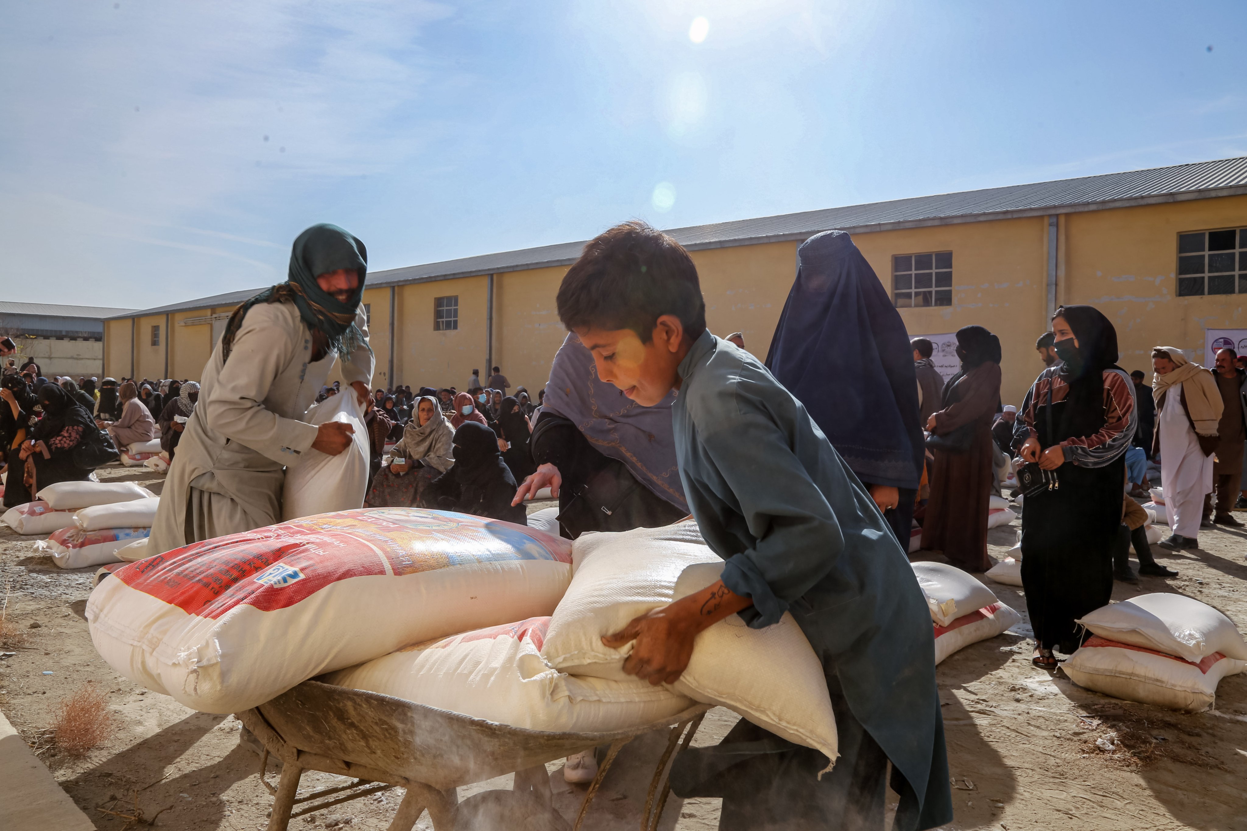 Afghan people carry food rations distributed by an Afghanistan National Disaster Management Authority programme to support families impacted by natural disasters, in Kabul, Afghanistan, on January 1. The UN Office for the Coordination of Humanitarian Affairs (OCHA) estimates that 22.9 million people in Afghanistan will require humanitarian aid in 2025. Photo: EPA-EFE