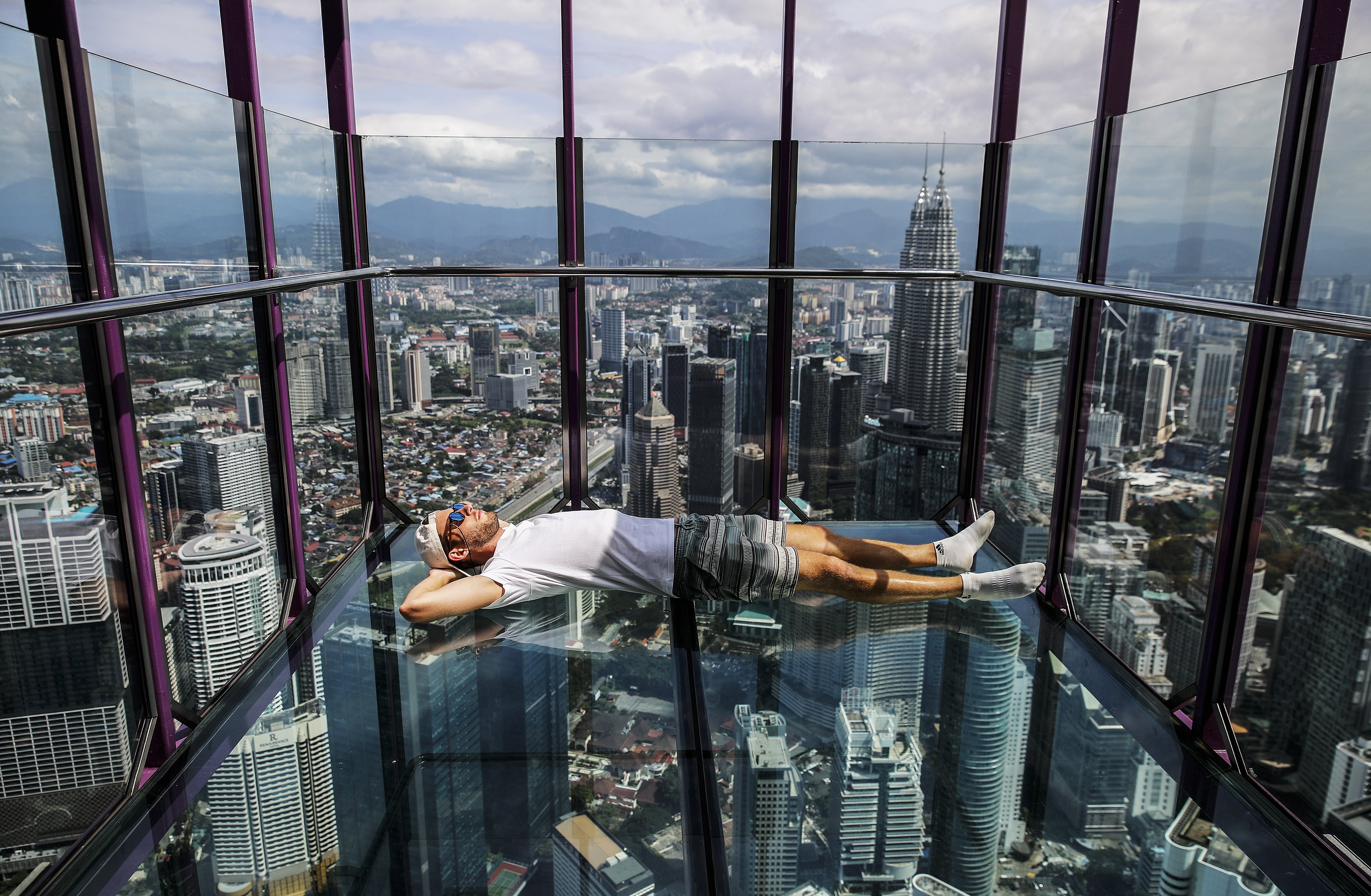 A visitor lies down in Kuala Lumpur Tower’s “Sky Box”, one of the city’s most popular tourist attractions, in Kuala Lumpur, Malaysia, in January 2024. Photo: EPA-EFE