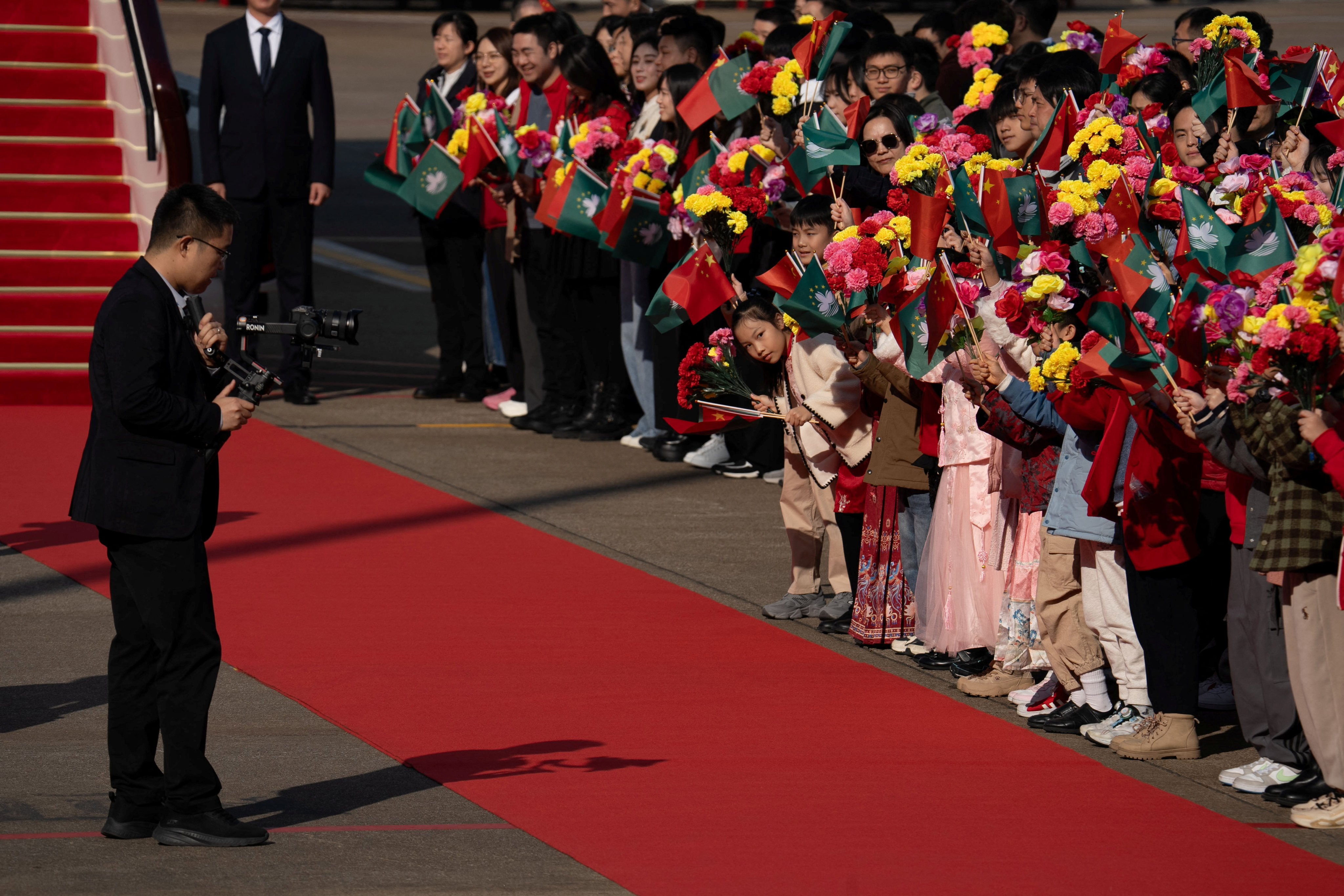 Children wave flags of Macau and China before the departure of President Xi Jinping at Macau International Airport on December 20. Photo: Reuters