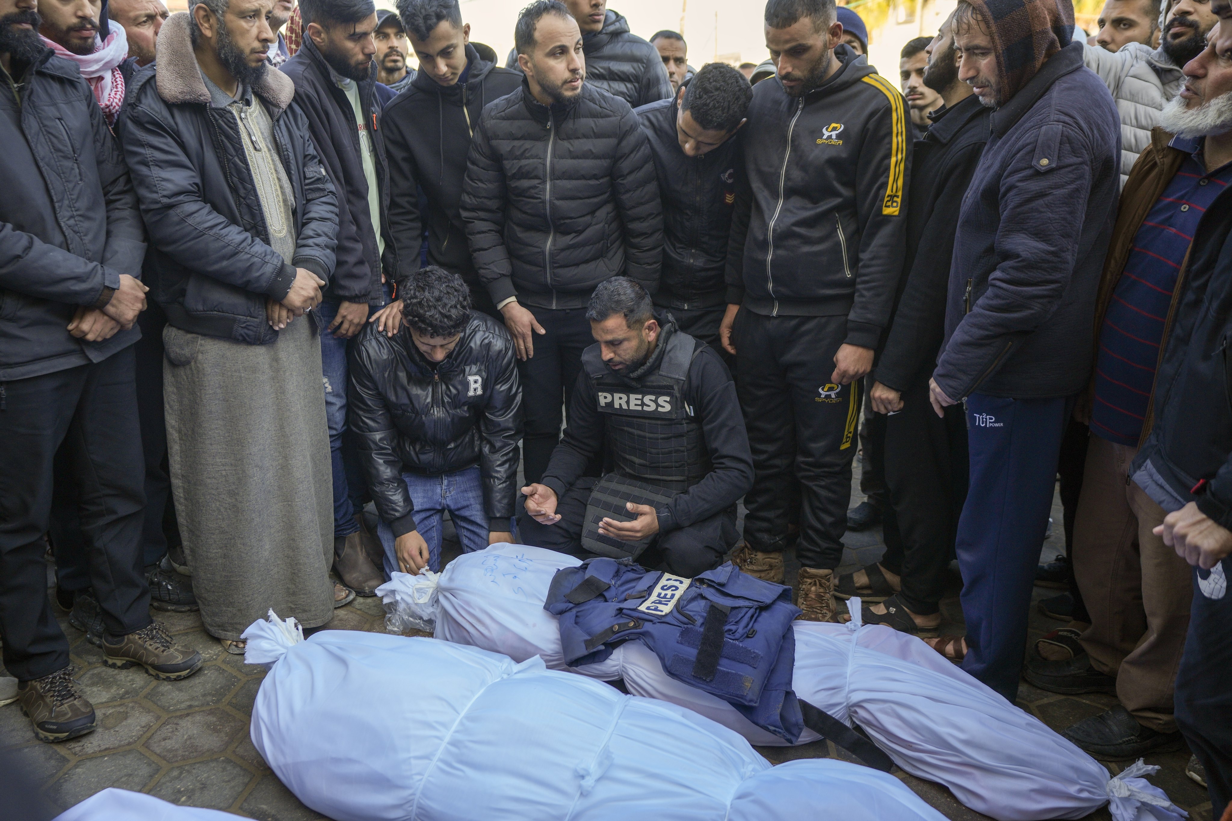 Colleagues and friends mourn over the body of freelance journalist Omar al-Derawi and other victims of Israeli strikes in Gaza on Friday. Photo: AP