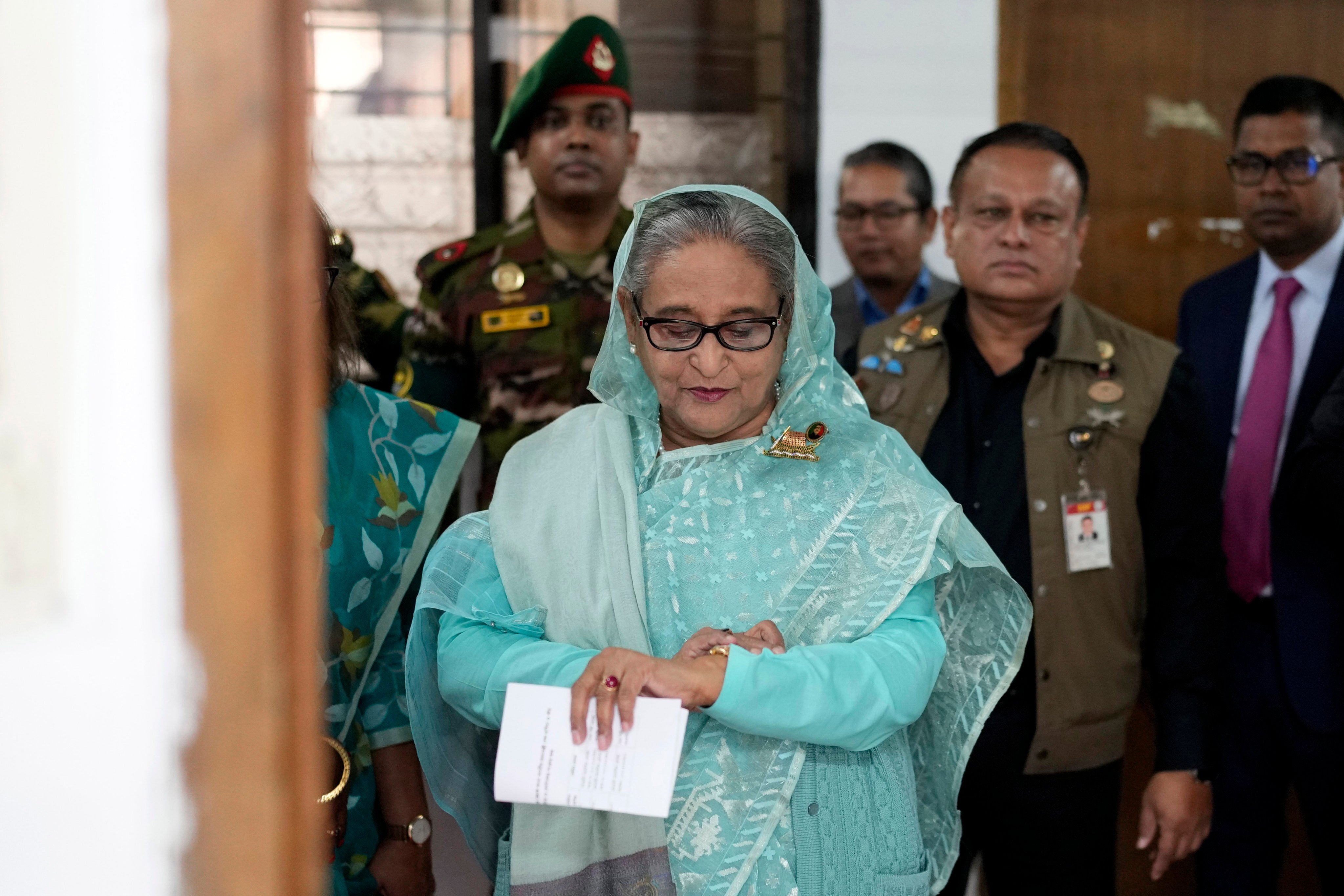 Former Bangladesh Prime Minister Sheikh Hasina checks her watch as she waits for the official opening time to cast her vote in Dhaka, Bangladesh, on January 7, 2024. Photo: AP