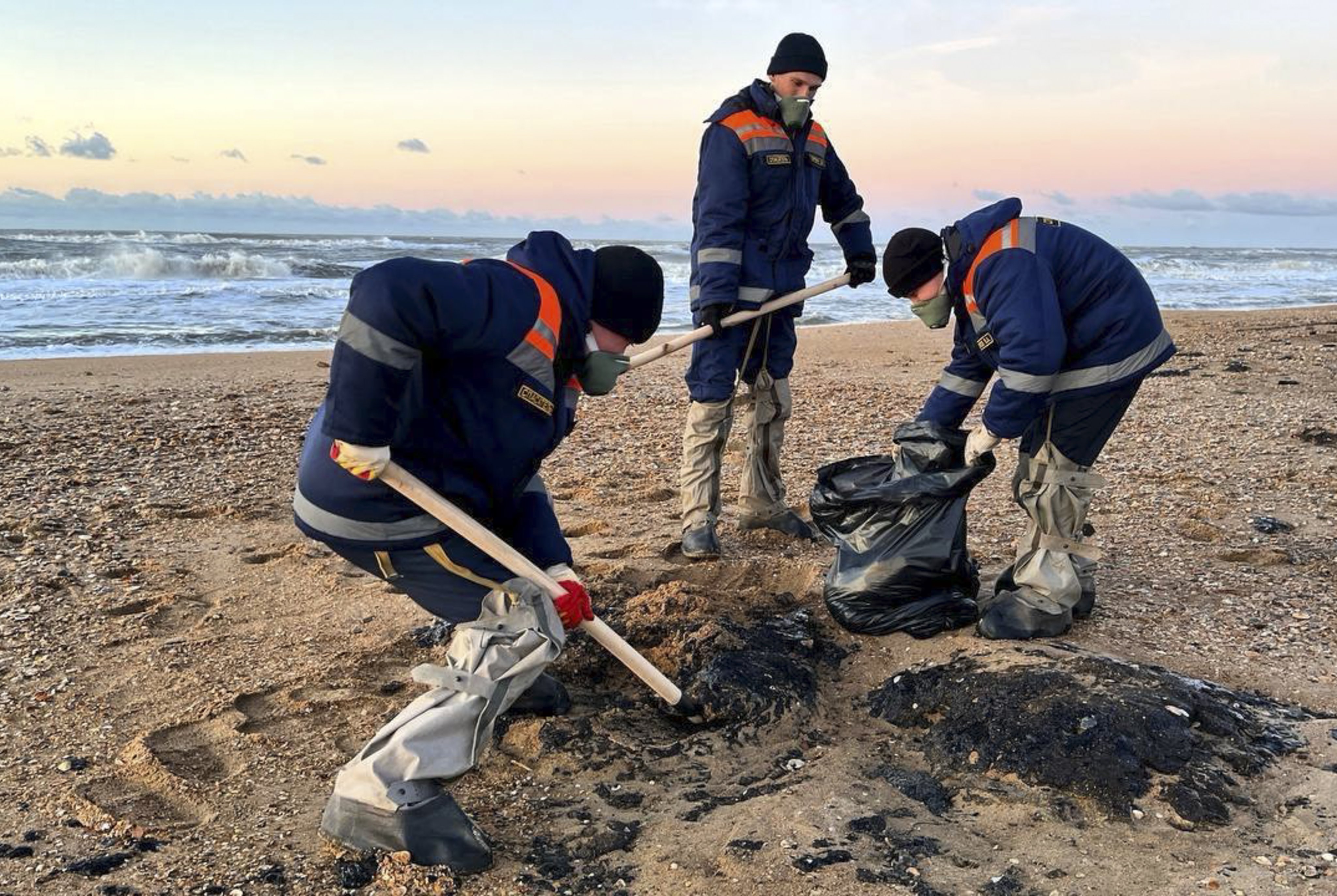 Employees of the Russian Ministry of Emergency Situations collecting oil-soaked beach sand during an oil spill clean-up operation in the Kerch Strait, Russia, on December 18, 2024. Photo: EPA-EFE