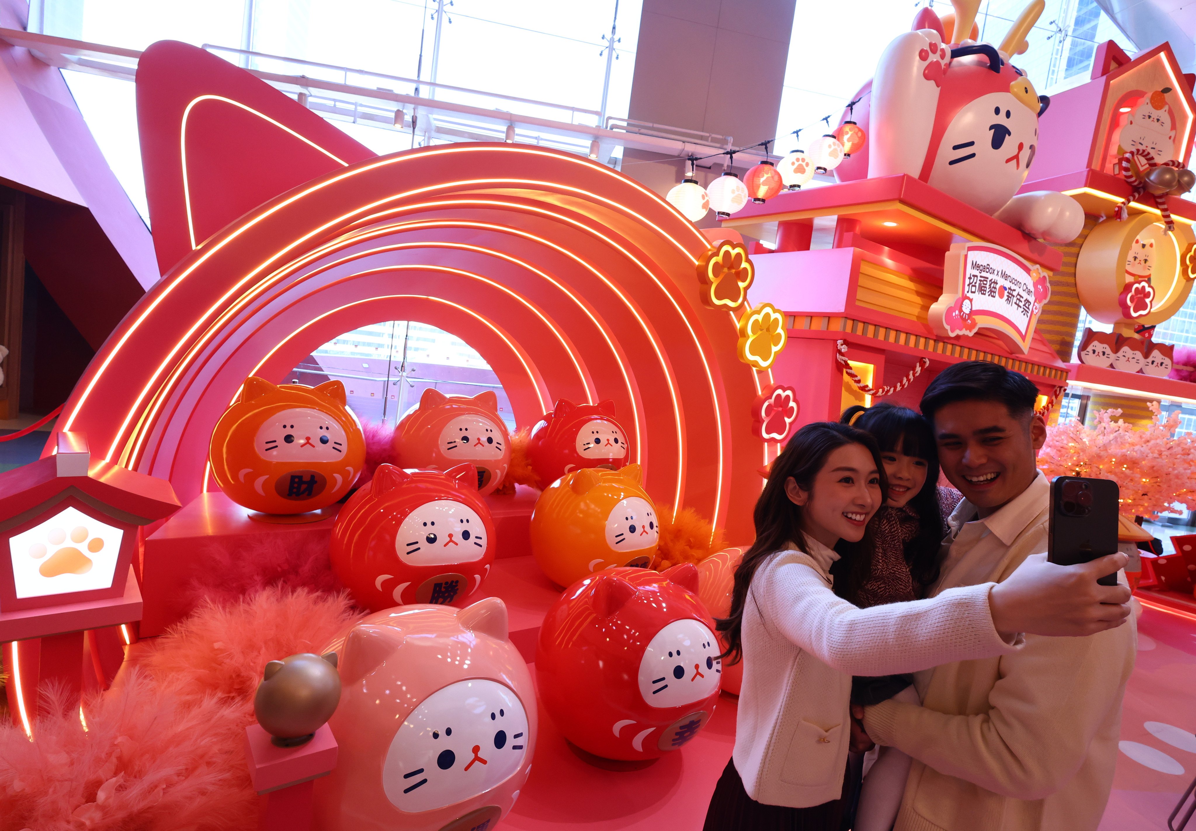 A family poses for a photo with a Lunar New Year installation at MegaBox shopping centre. Photo: Dickson Lee