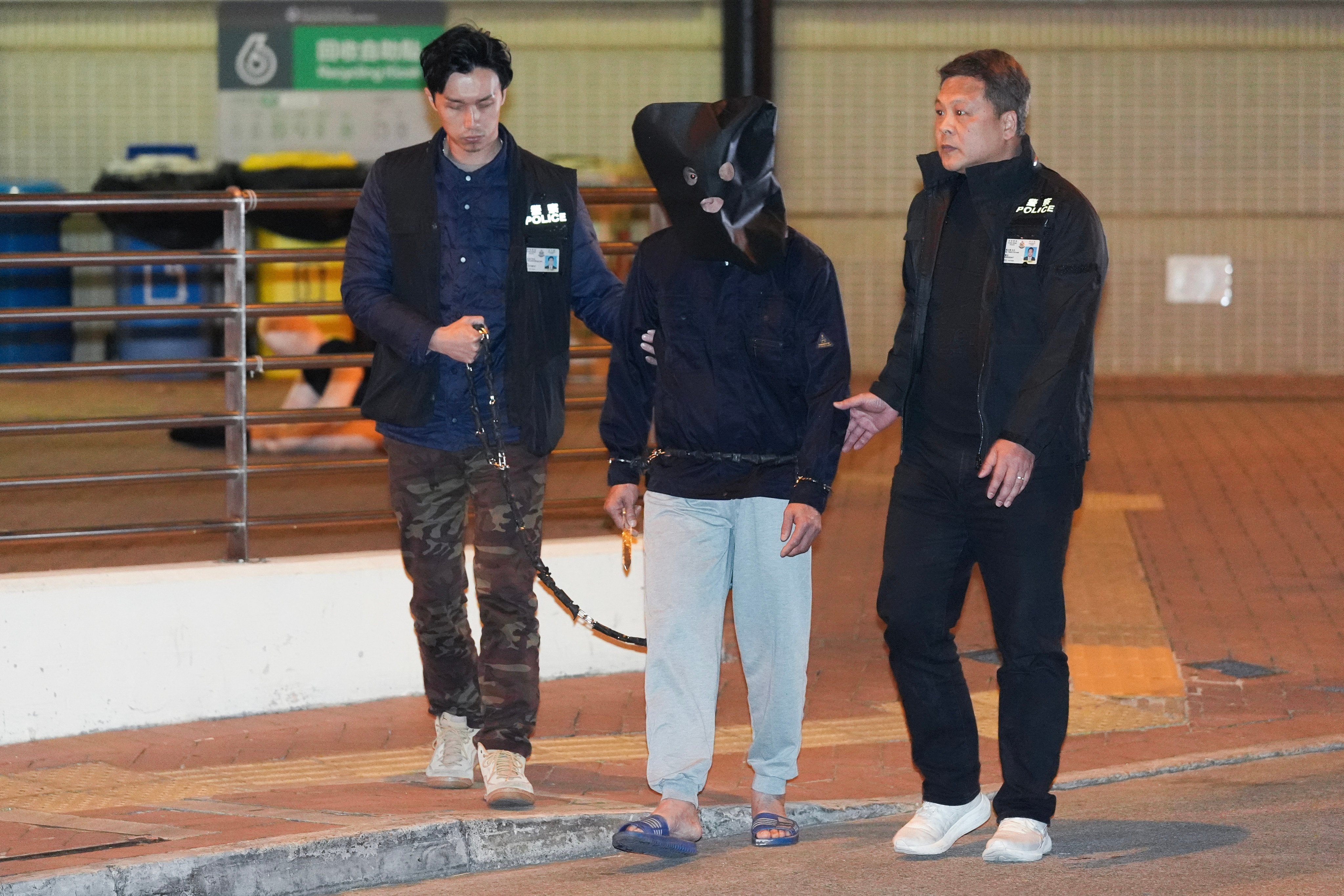 Police officers bring the 56-year-old suspect to Po Tin Estate in Tuen Mun  for a re-enactment of the crime. Photo: Eugene Lee