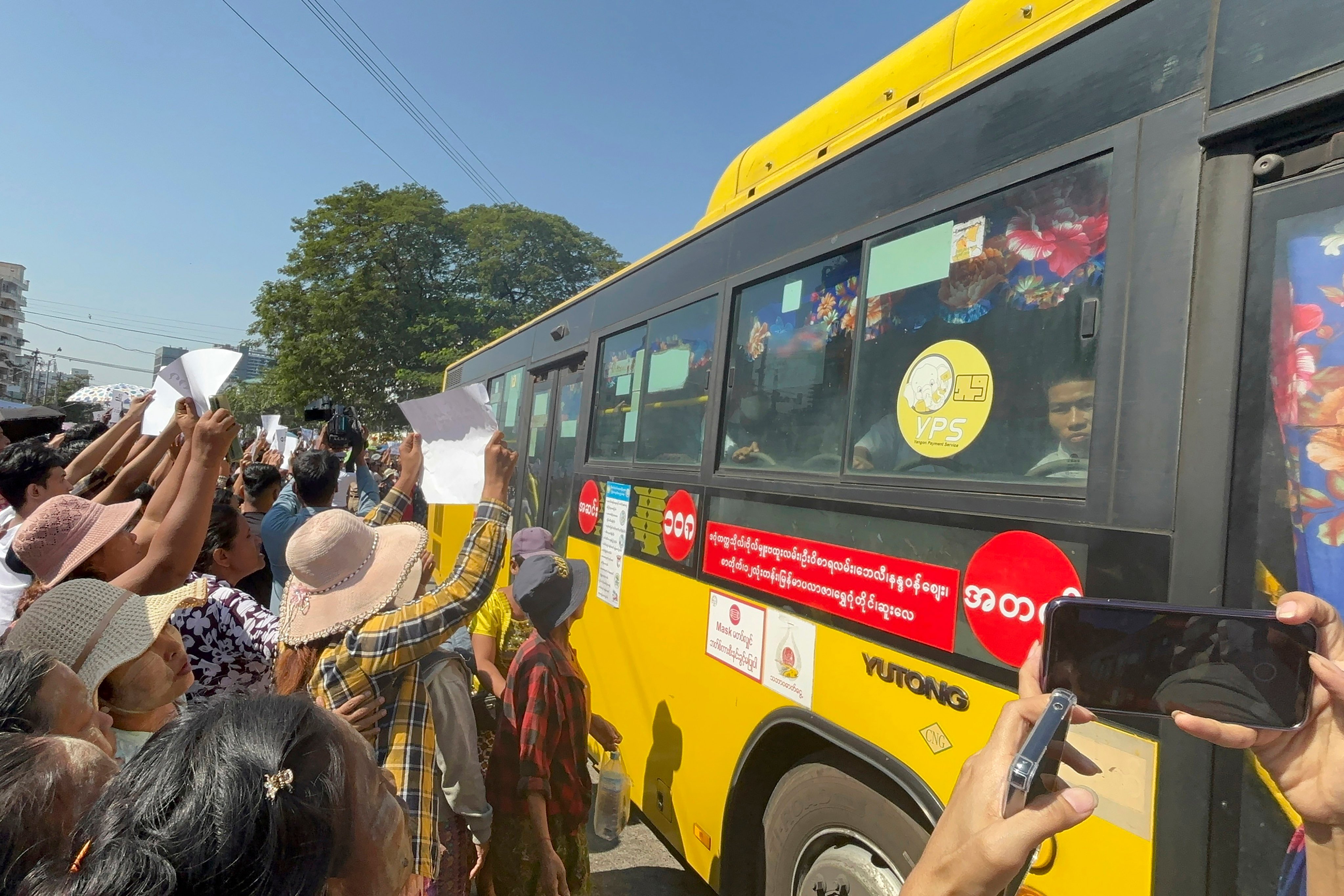 Released prisoners, in a bus, are welcomed by family members and colleagues after they left Insein Prison, on Saturday, in Yangon, Myanmar. Photo: AP