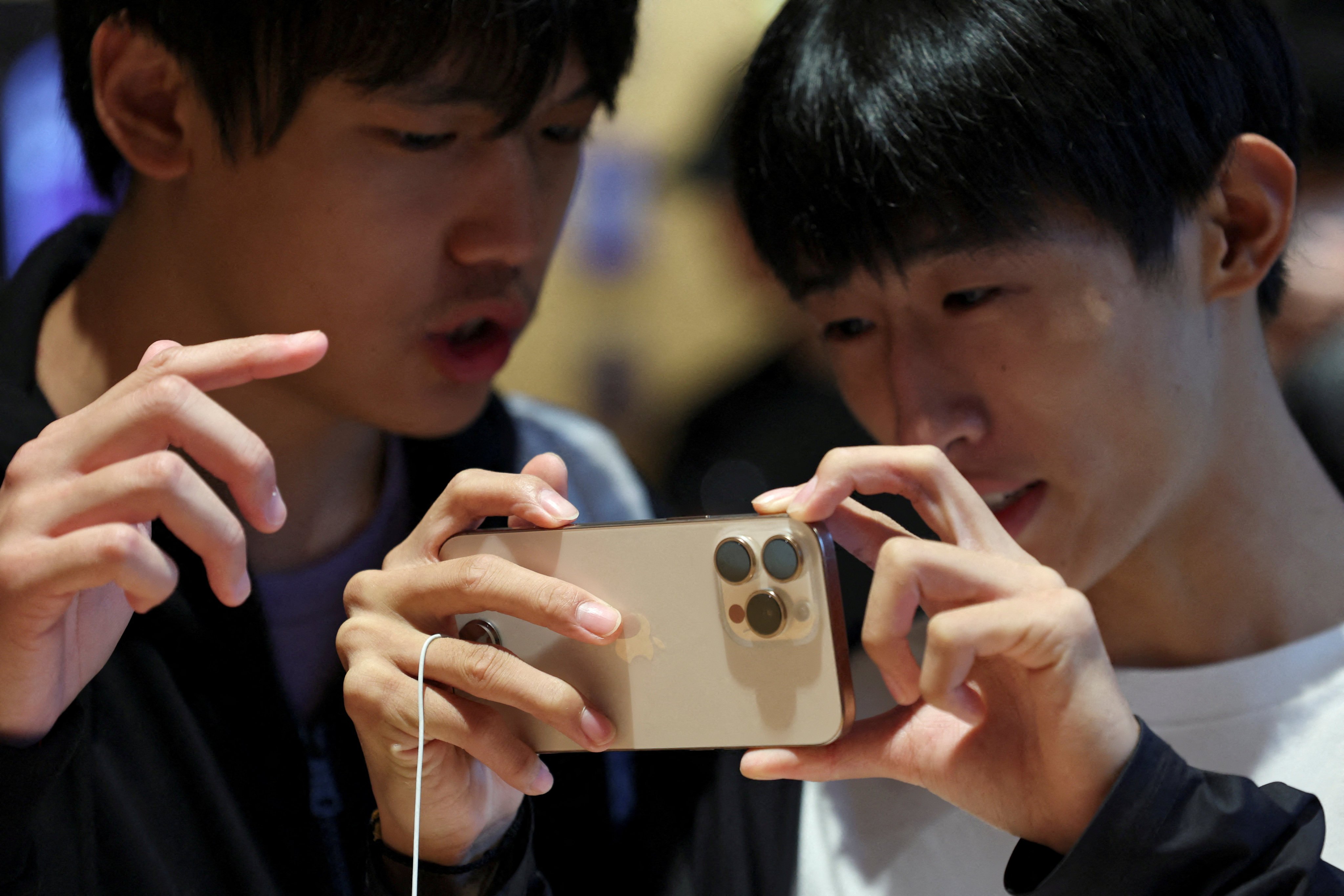 Men check out an iPhone 16 Pro at an Apple store in Beijing on September 20, 2024. Photo: Reuters