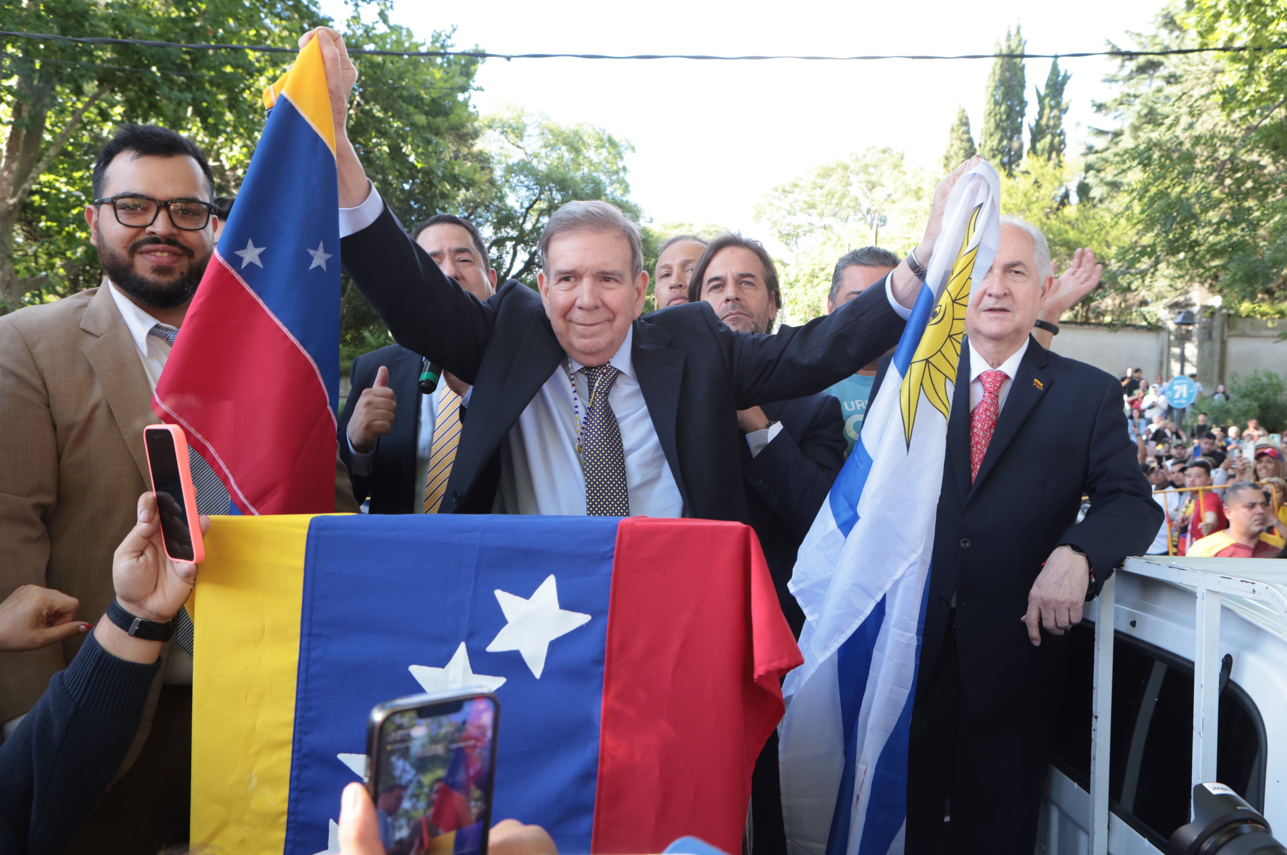 Venezuelan opposition leader Edmundo Gonzalez Urrutia (cetre) holds the flags of Venezuela and Uruguay during a press conference in Montevideo, Uruguay, on Saturday. Photo: EPA-EFE