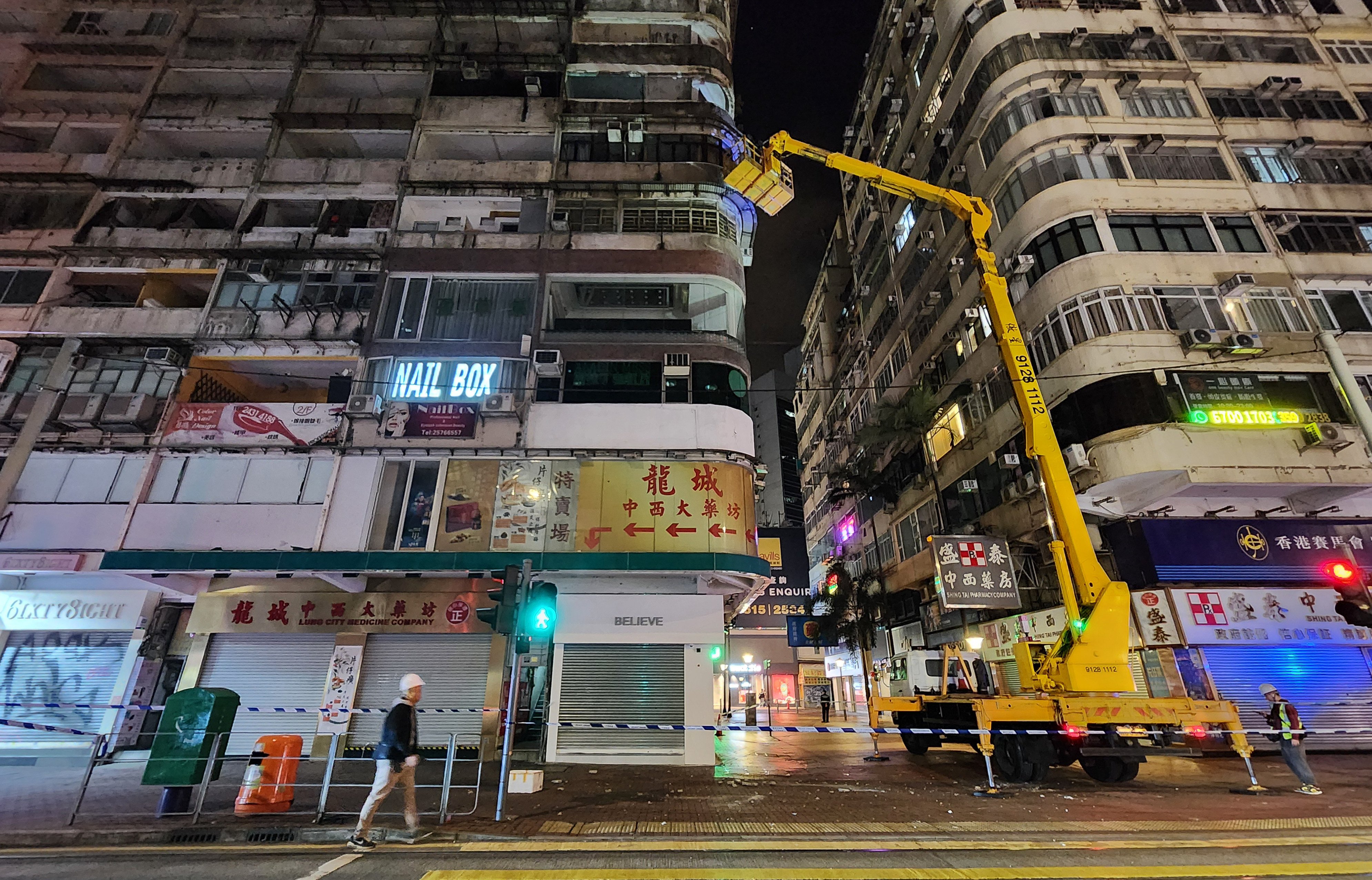 Contractors inspect the building at No 76 Percival Street in Causeway Bay. Photo: Harvey Kong