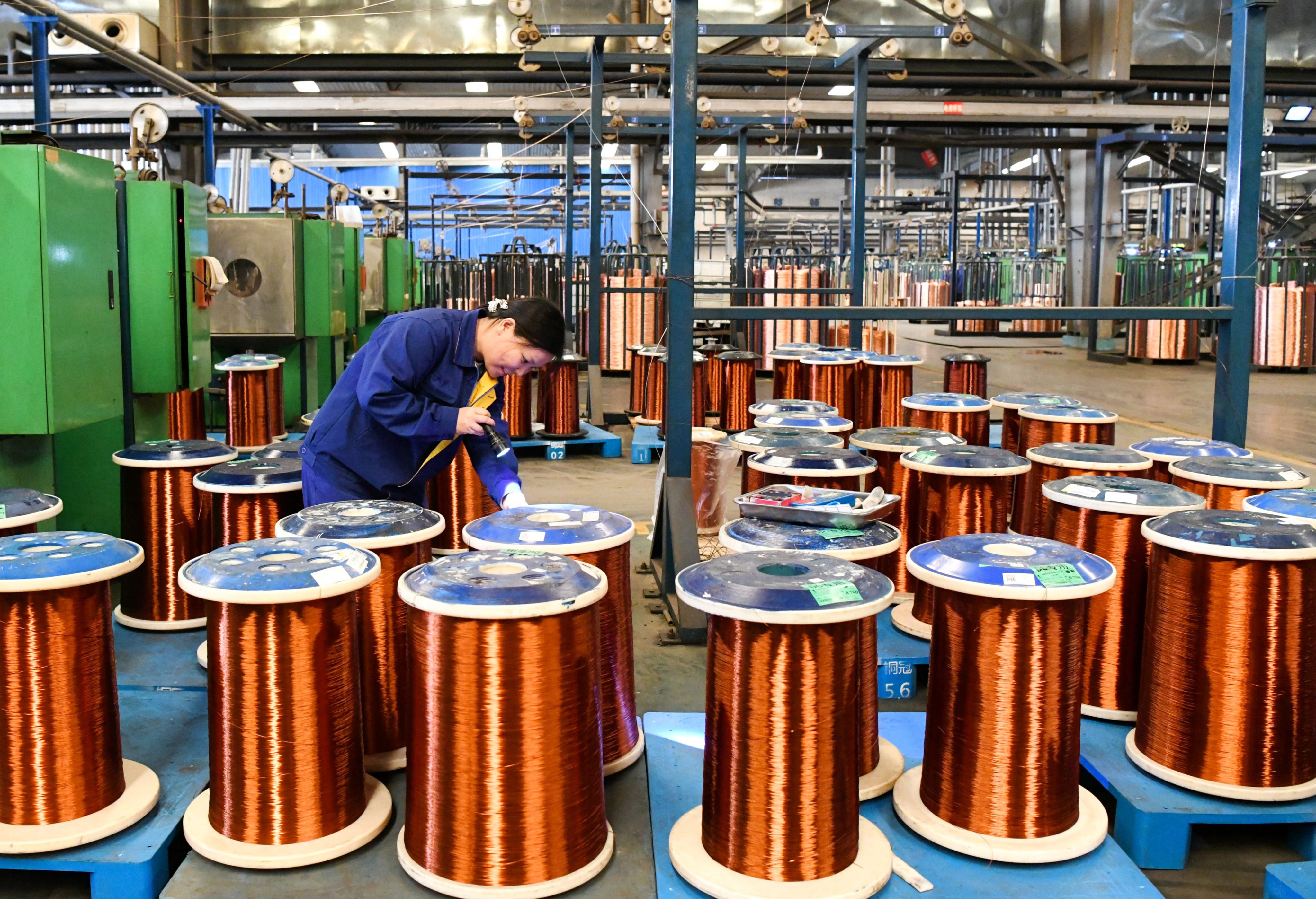 An employee handles copper wires at a workshop in China’s Anhui province. Photo: Getty Images