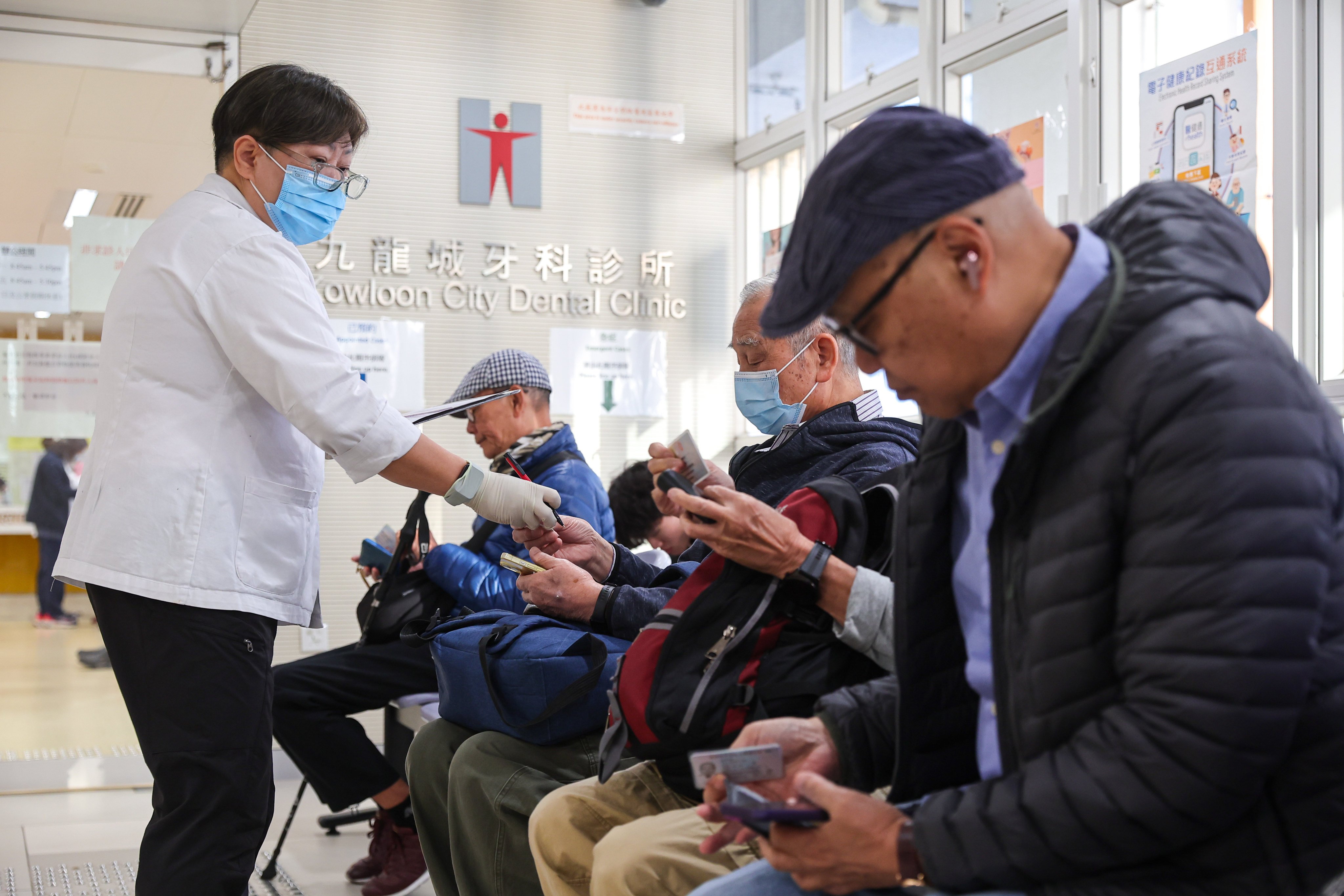 A staff member attends to people waiting at Kowloon City Health Centre in Hung Hom. Photo: Edmond So