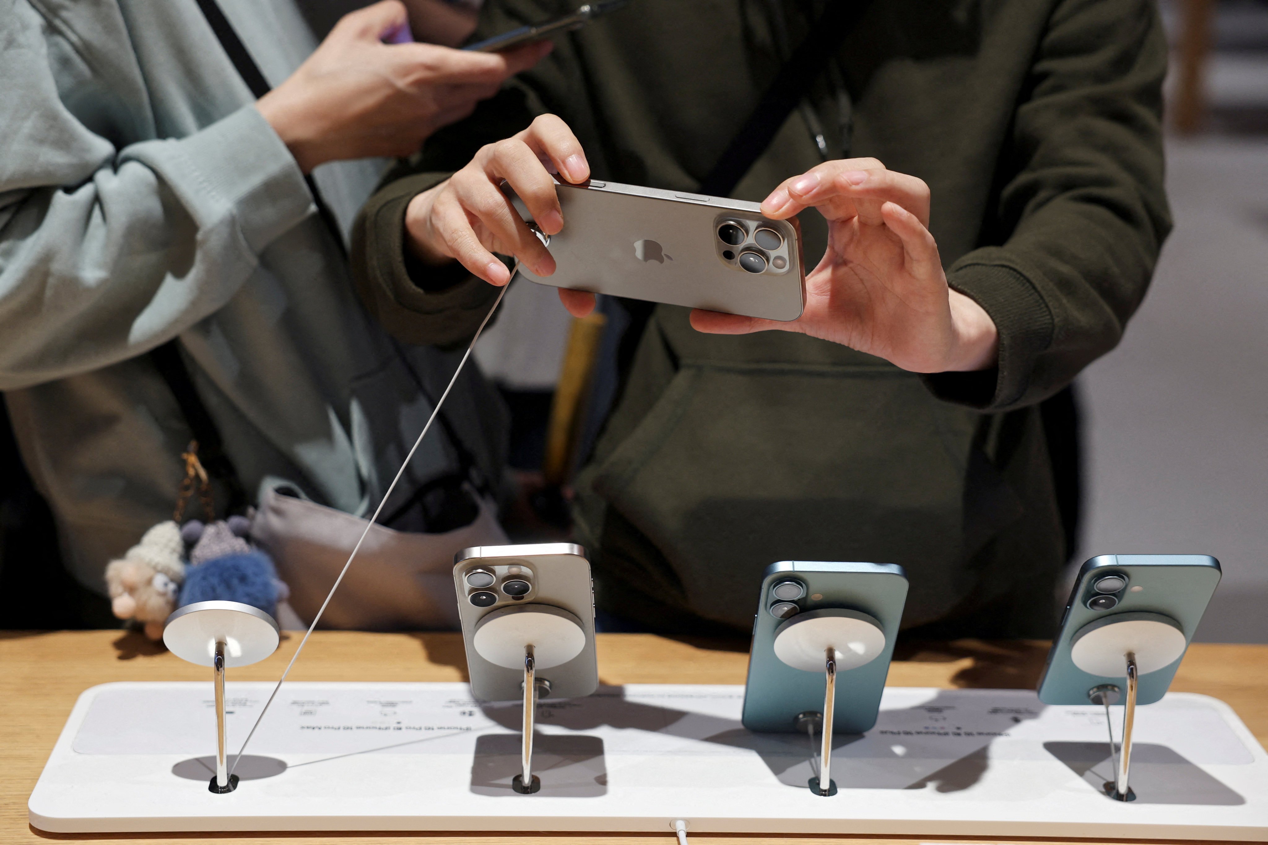 A man checks an iPhone 16 Pro Max at an Apple store in Beijing, China September 20, 2024. Photo: Reuters