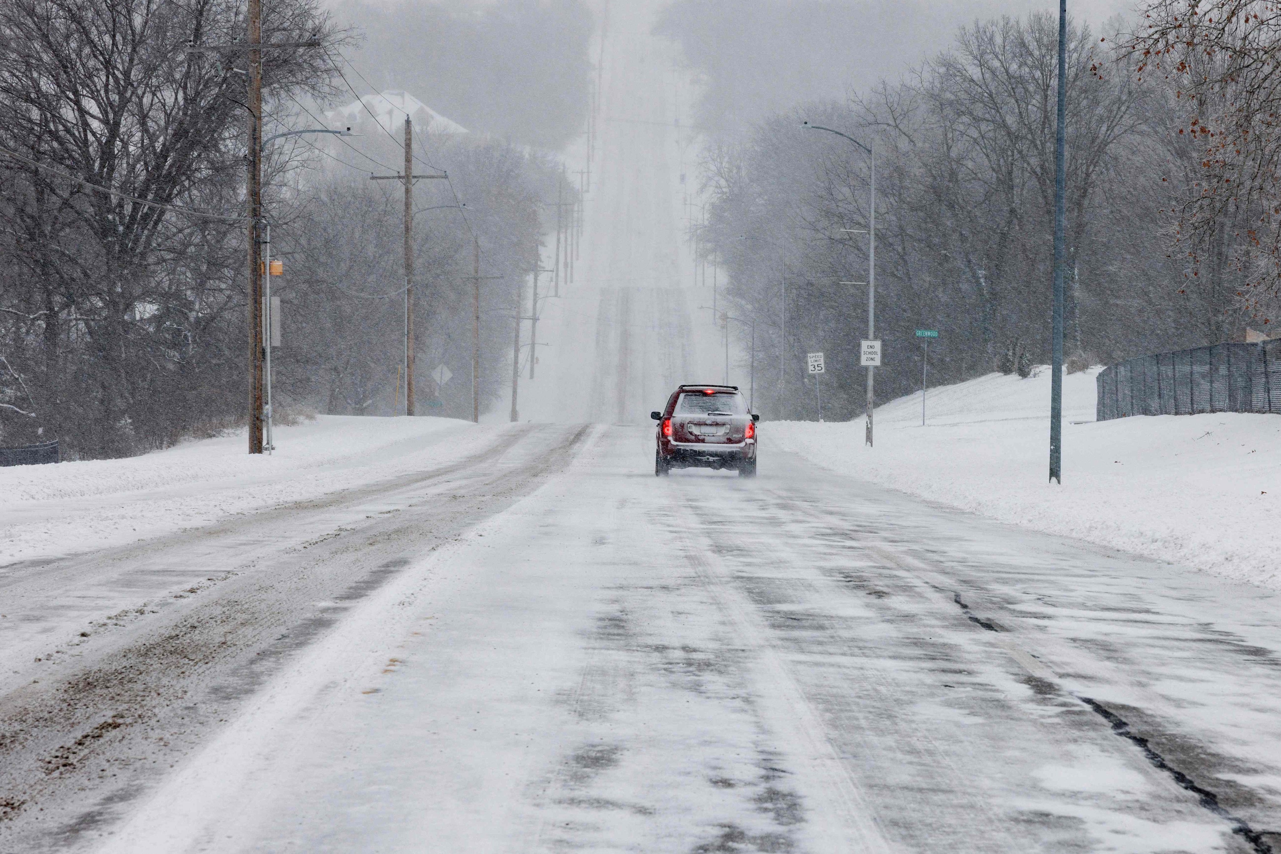 A car cautiously drives down a snowy road in Shawnee, Kansas on Sunday. Photo: Getty Images / AFP