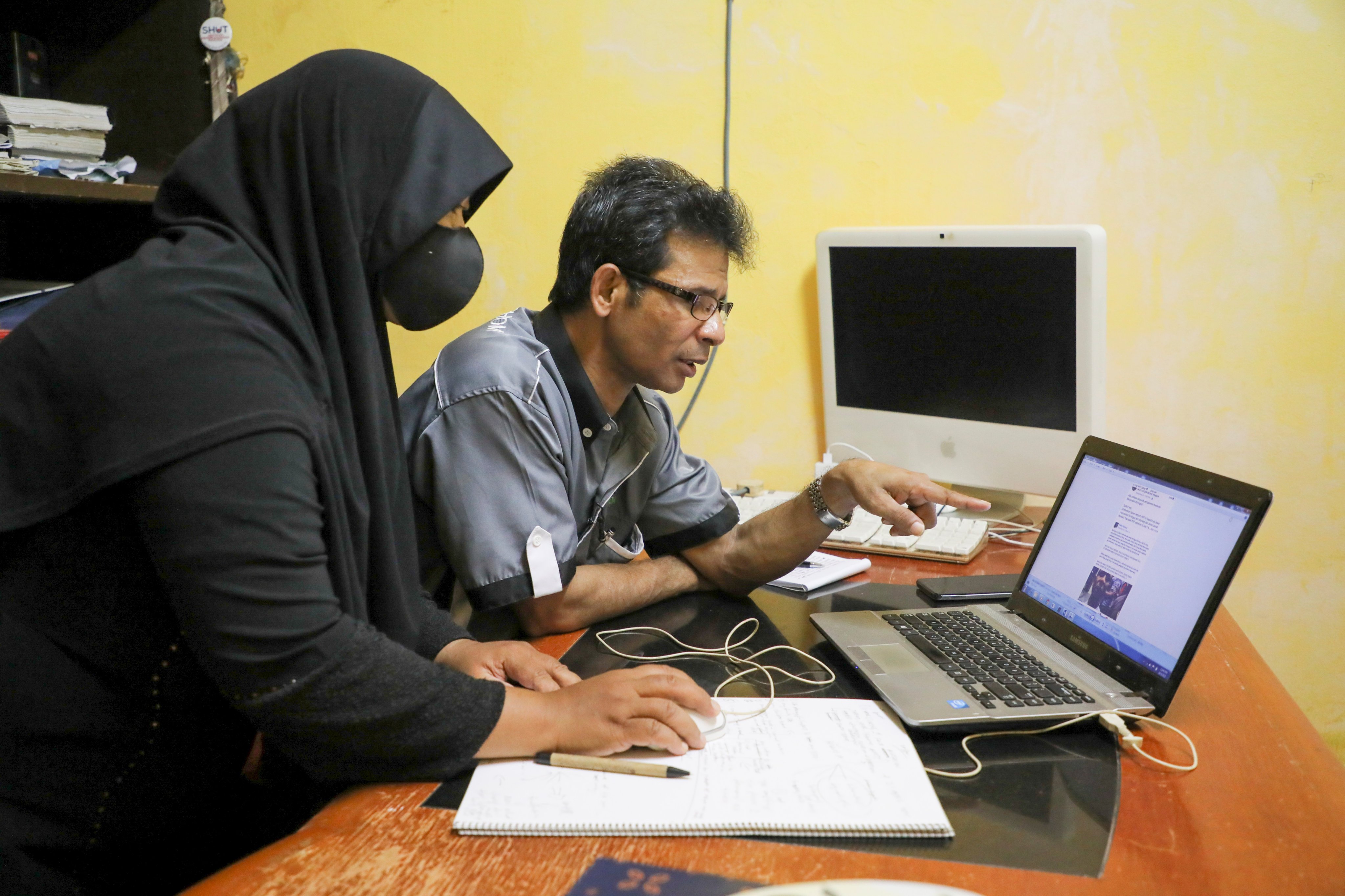 A Rohingya refugee and his wife look at a computer screen displaying threats and hate speech they have received, at their home in Kuala Lumpur, Malaysia. Photo: Reuters