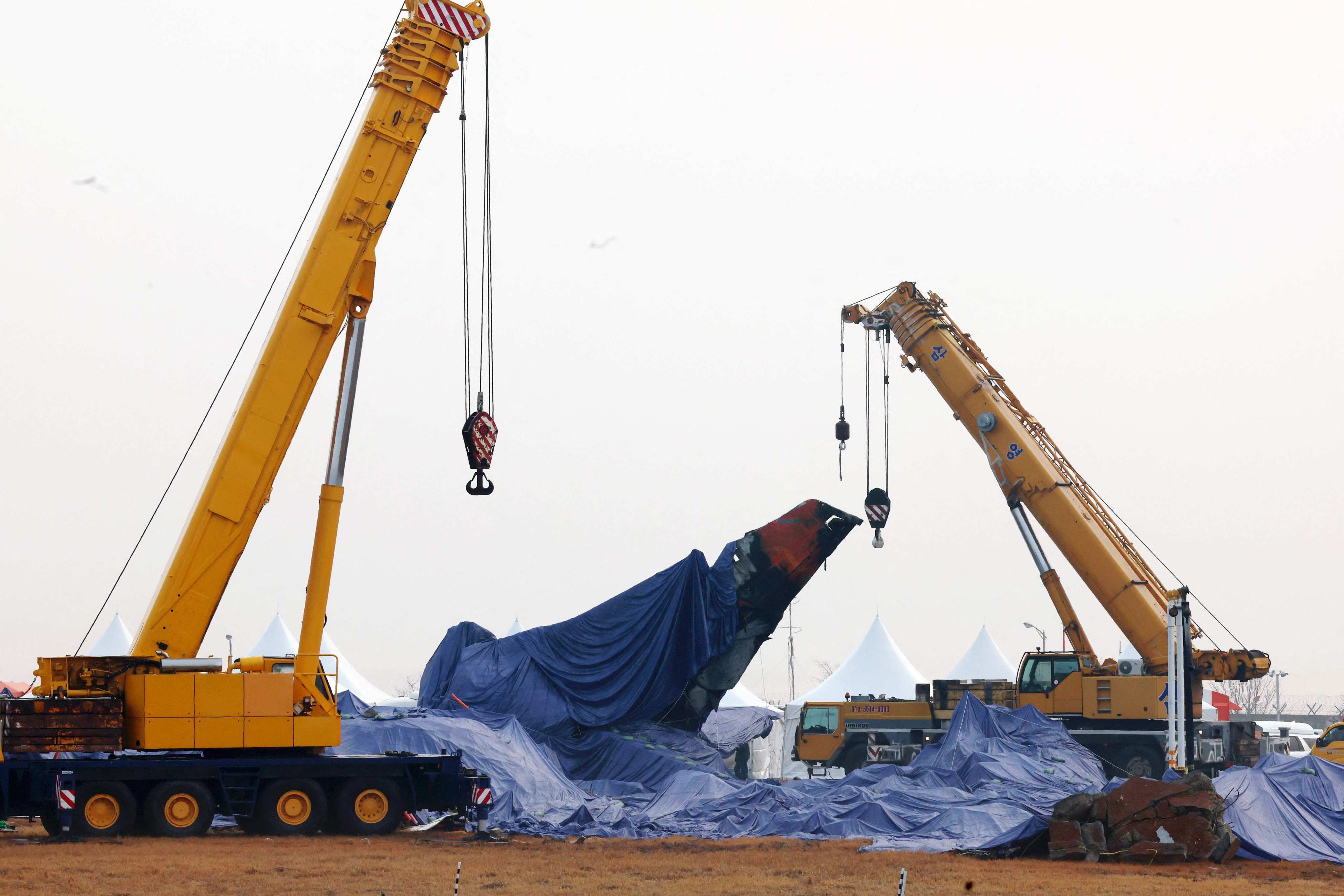 Tarpaulin shrouds the wreckage of the Jeju Air Boeing 737-800 aircraft, which on December 29 crashed and burst into flames at Muan International Airport. Photo: Yonhap/AFP