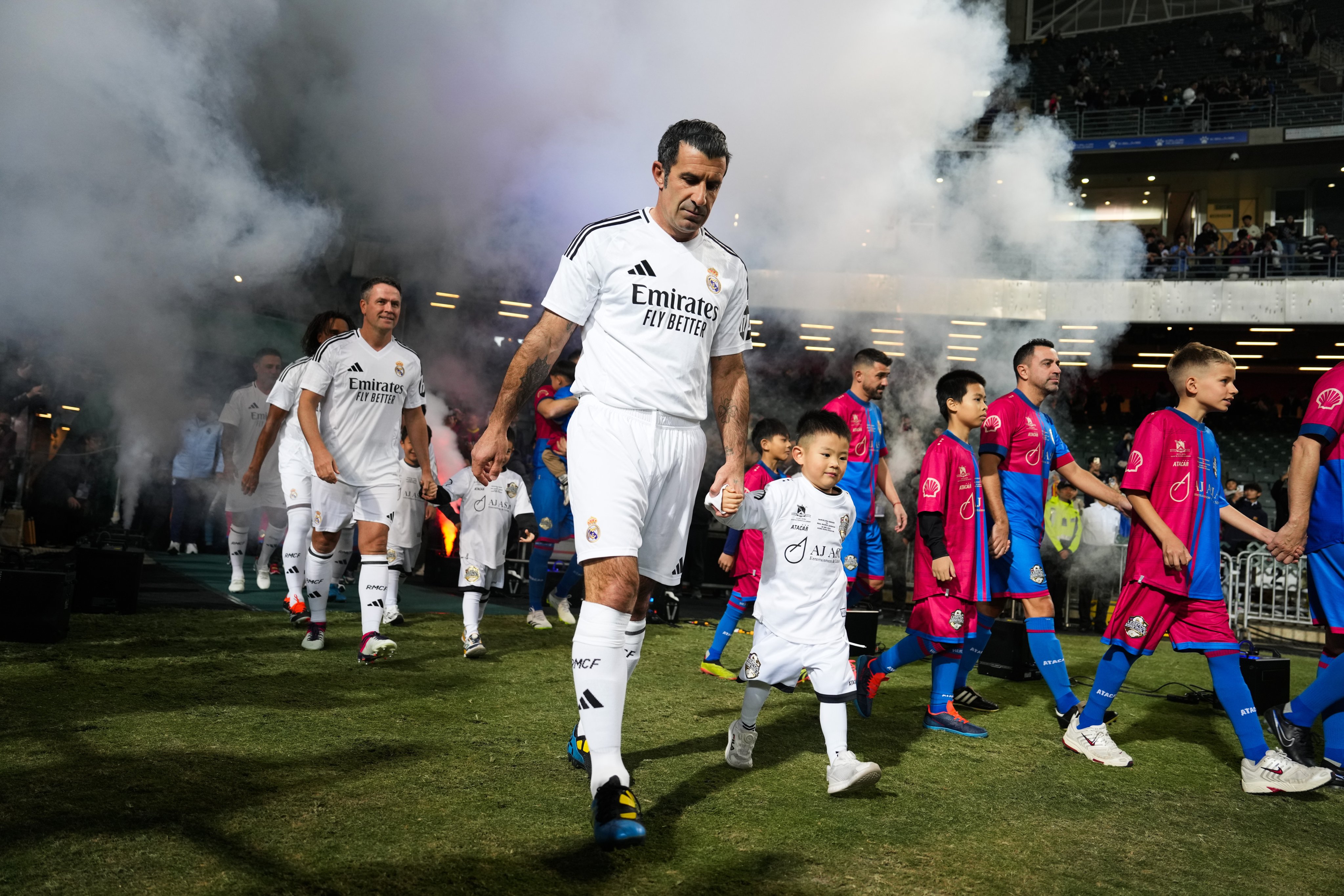 Luis Figo and other players enter the pitch ahead of a friendly match at Hong Kong Stadium on December 20. Photo: EPA-EFE