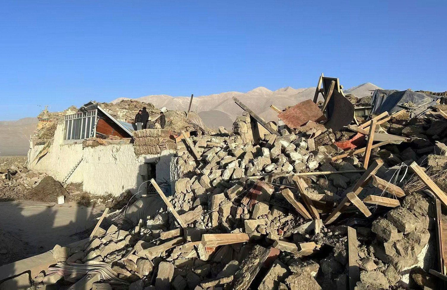 People sift through rubble in the aftermath of a magnitude 6.8 earthquake in China’s southern Tibet autonomous region on Tuesday morning. Photo: Xinhua 