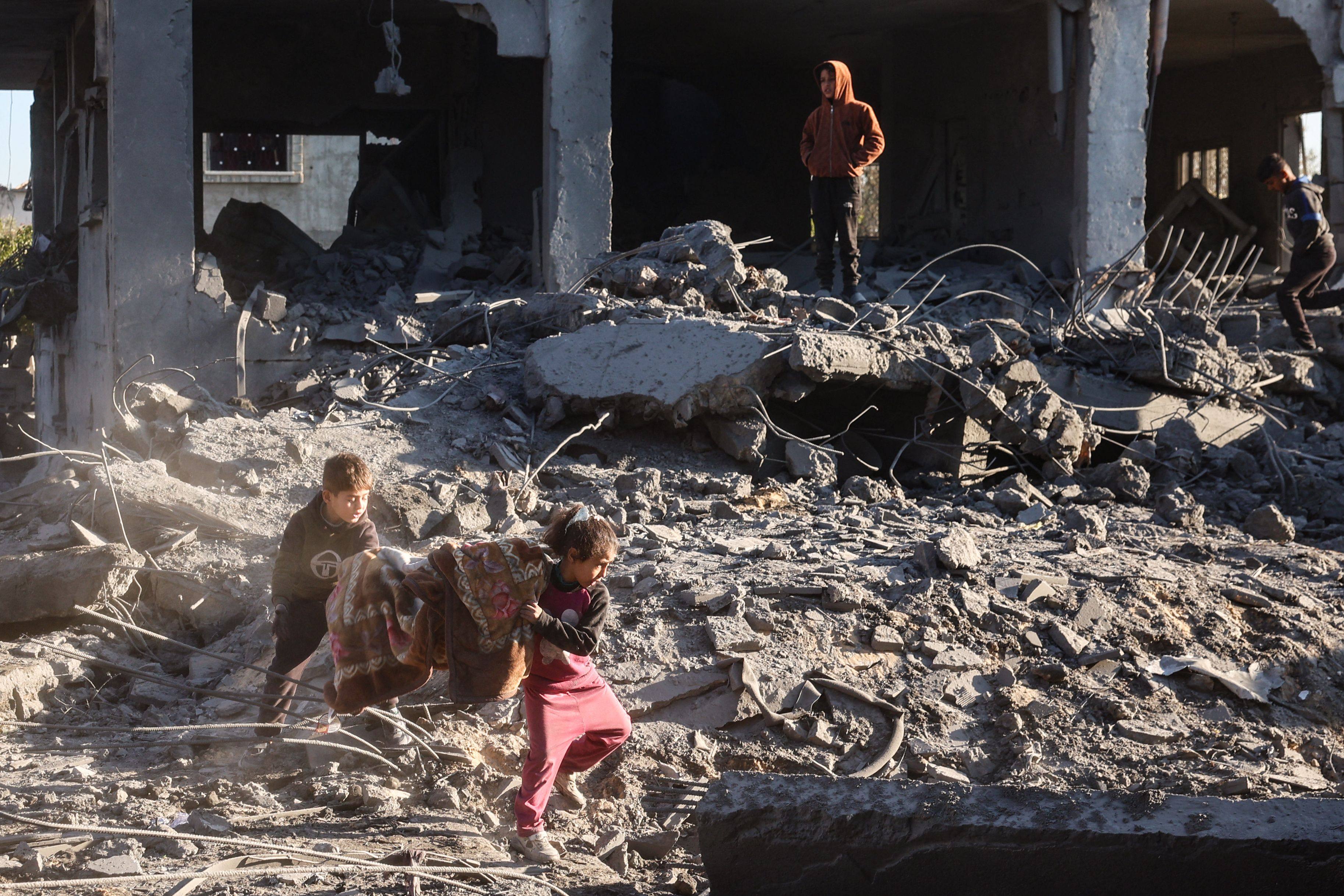 Palestinian children salvage a blanket amid the destruction in the aftermath of an Israeli strike in the al-Maghazi refugee camp in the central Gaza Strip on January 3, 2025. Photo: AFP