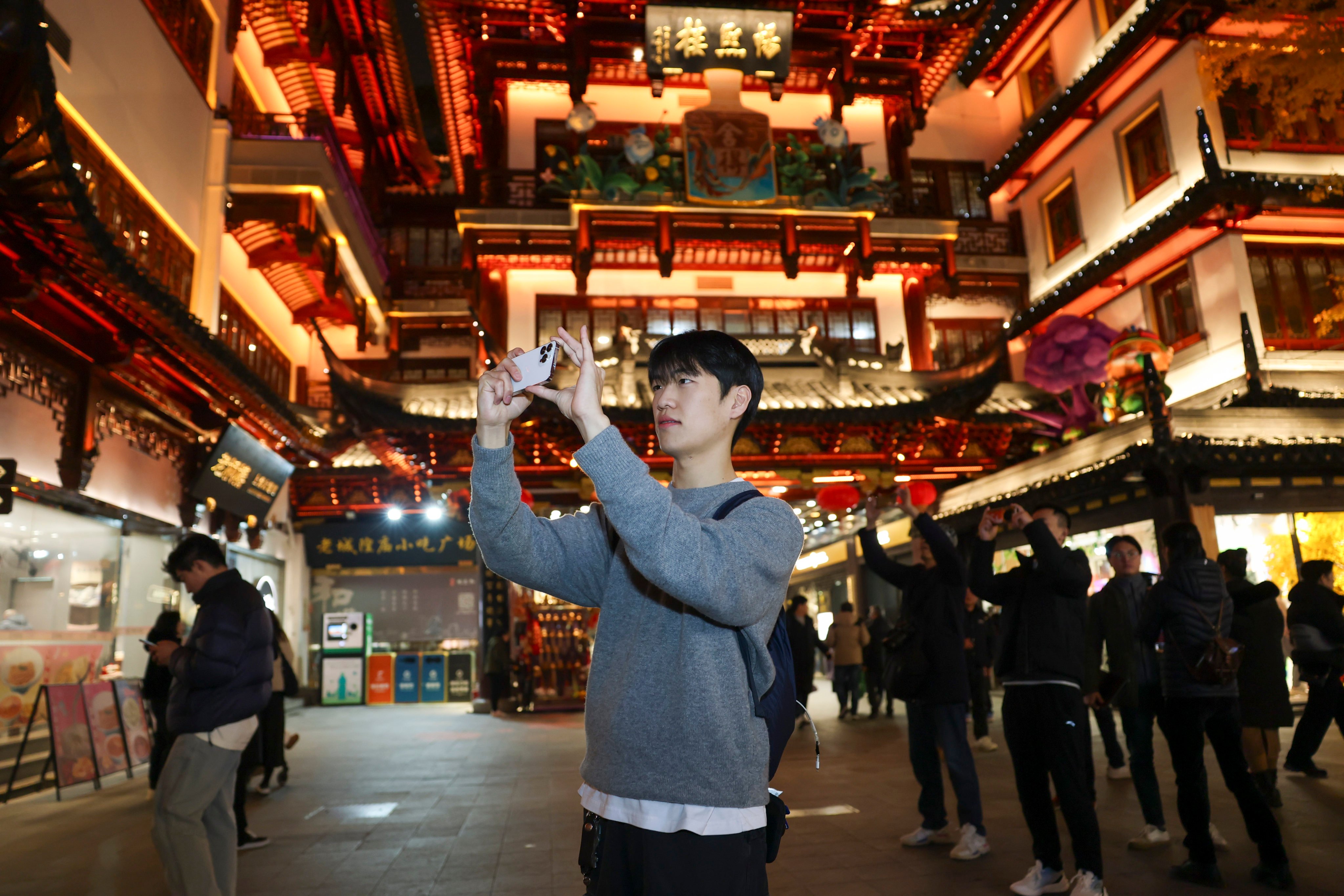 A South Korean tourist takes photos at Yuyuan Garden Mall in China’s Shanghai on Christmas Day. Photo: Xinhua