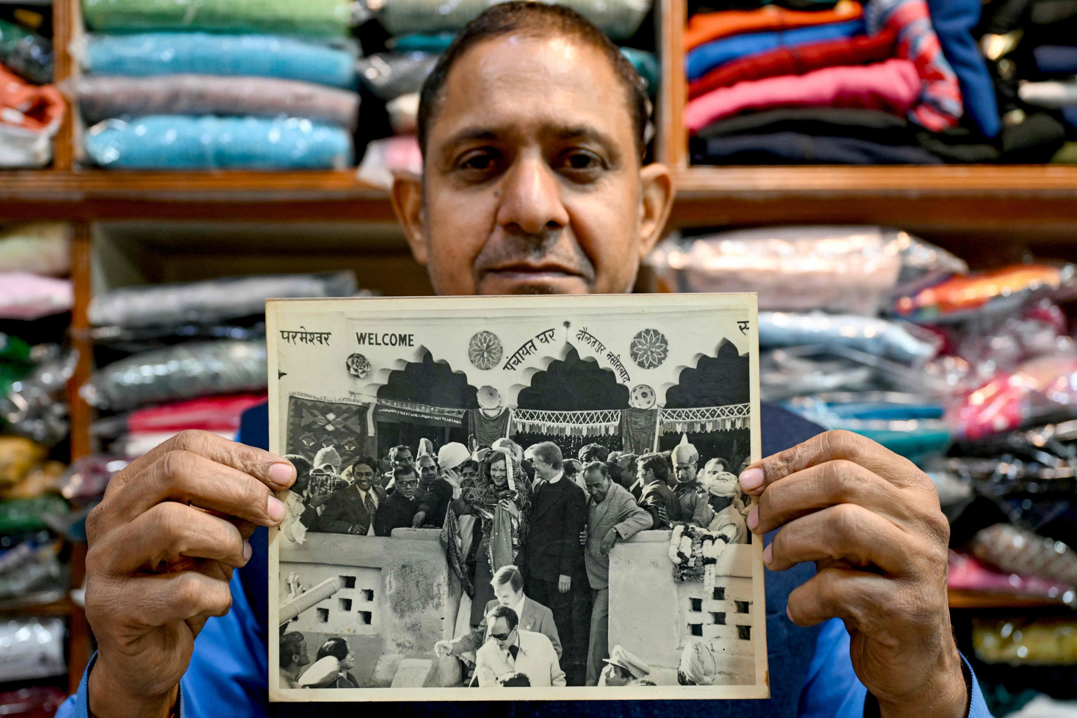 Resident Rajiv Kumar shows a photograph of late former US president Jimmy Carter and his wife Eleanor Rosalynn Carter during their visit in 1978. Photo: AFP